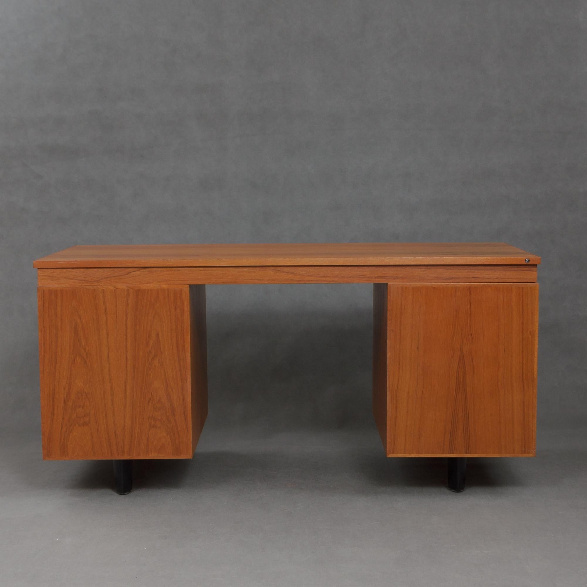 Large teak desk by Danish manufacturer Nipu. It features six asymmetrical drawers with file racks and organizers. It has two top sliding trays with original glass marked 