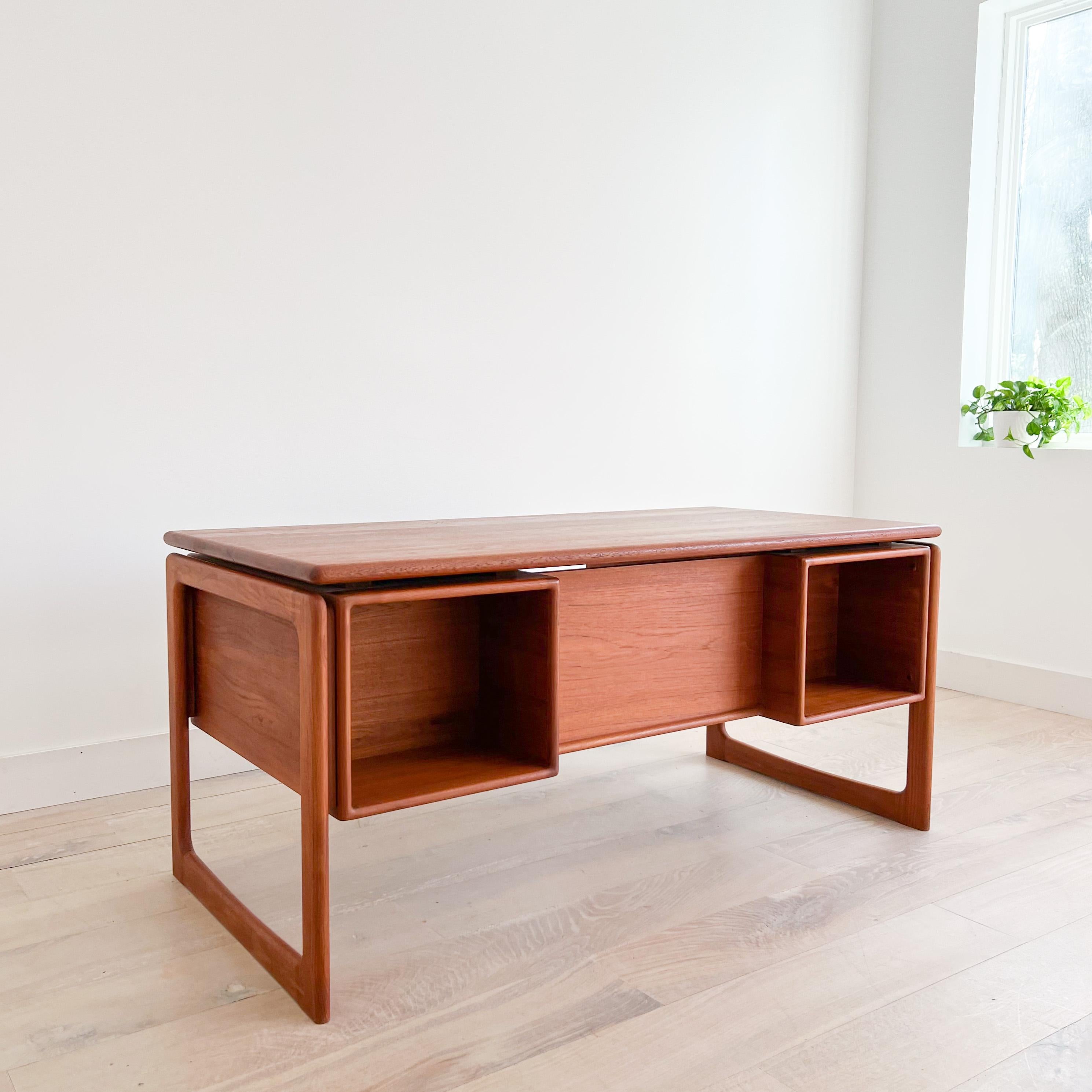 Mid-Century Modern danish teak executive desk with finished back. Open cabinets on the backside for storage or display. The top has been sanded and restored. Some scuffing/scratching from age appropriate wear. The drawers open and close with ease.