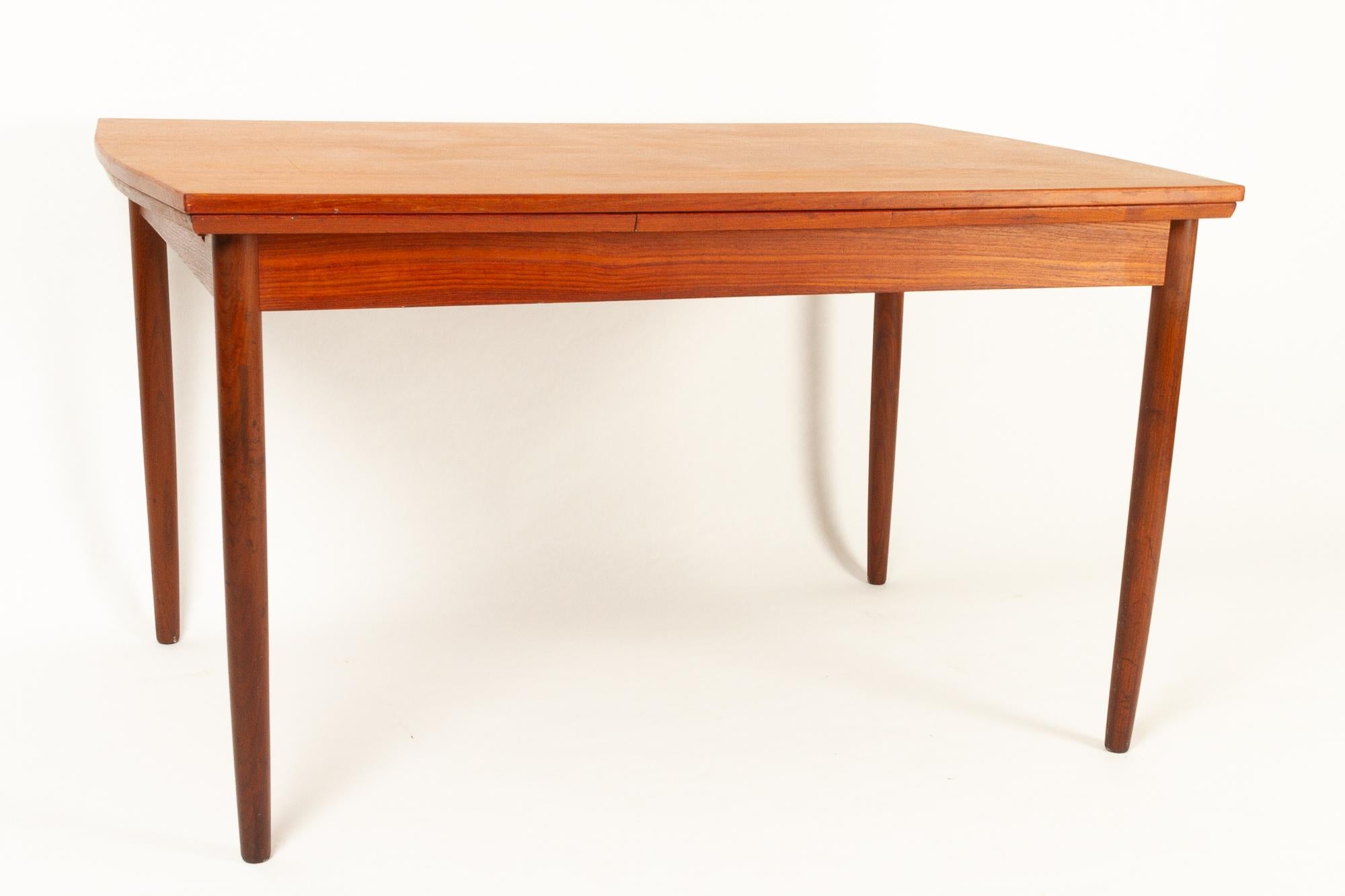Danish teak extendable dining table, 1960s.
Rectangular Danish Mid-Century Modern dining room table with rounded table ends and extractable leaves. Round tapered legs in solid teak. Lovely teak grain and colour. Very classic Scandinavian modern of