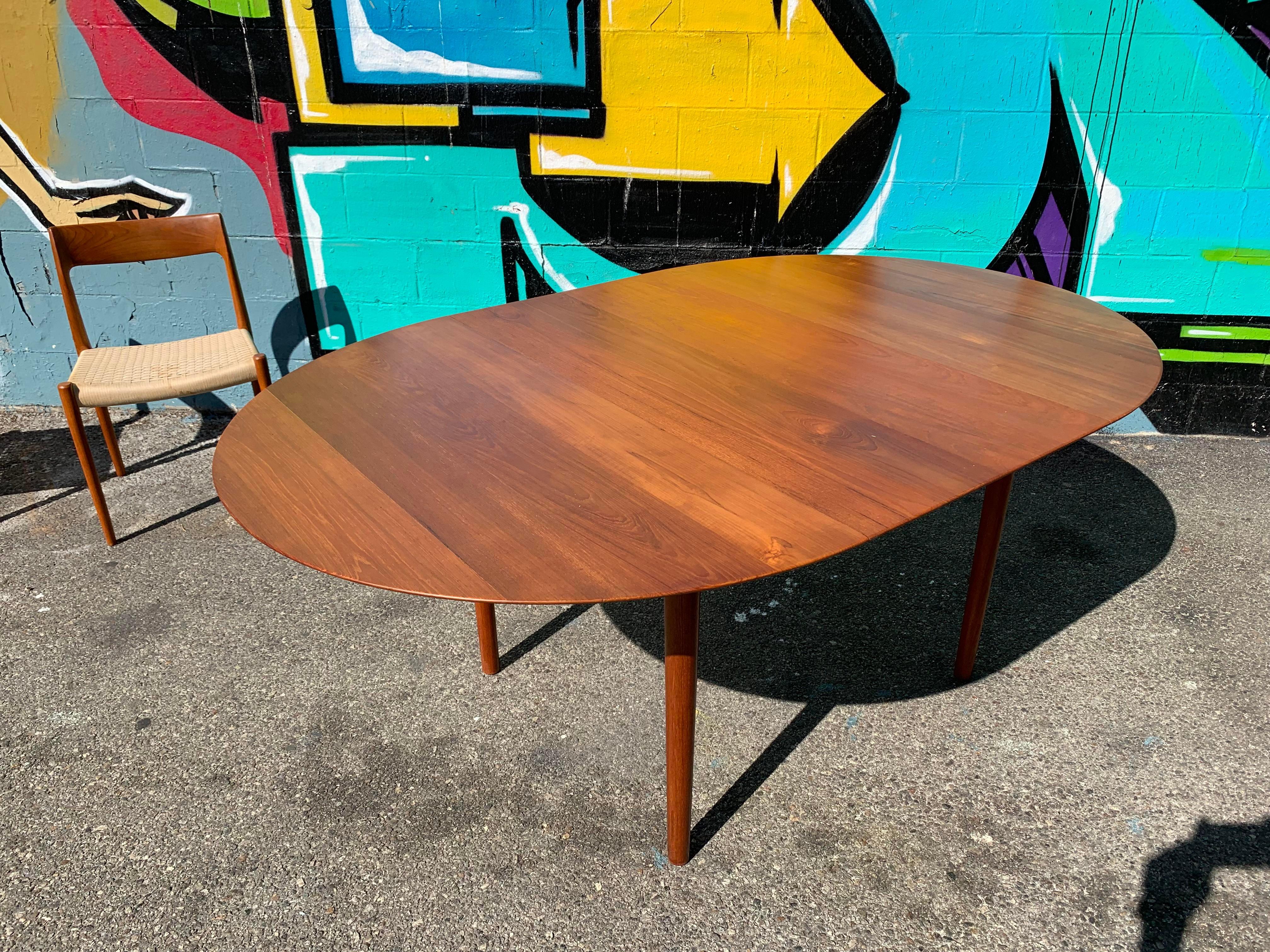 Beautiful sleek Danish teak oval shape dining table with a large 22