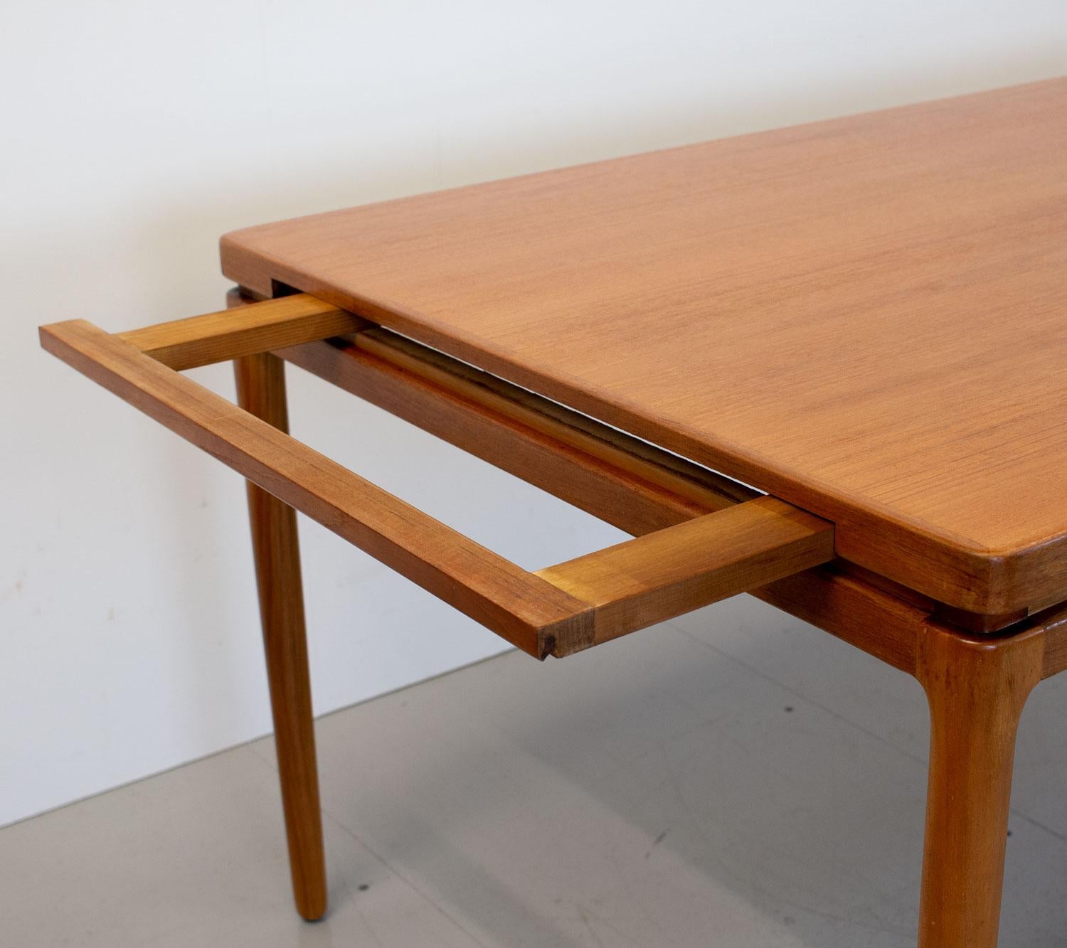 Danish teak extending dining table designed by Johannes Andersen for Christian Linneberg in the 1960s. This large table has superb design and construction with edge banding, surrounding rebate and hidden supports for the leaves that can take the