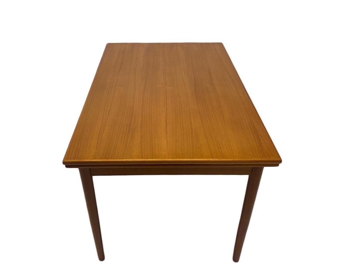 A beautiful Danish extending teak dining table, this would make a stylish addition to any dining or work area. A striking piece of classically designed Scandinavian furniture.

The table has two pull out extension panels which fit neatly underneath