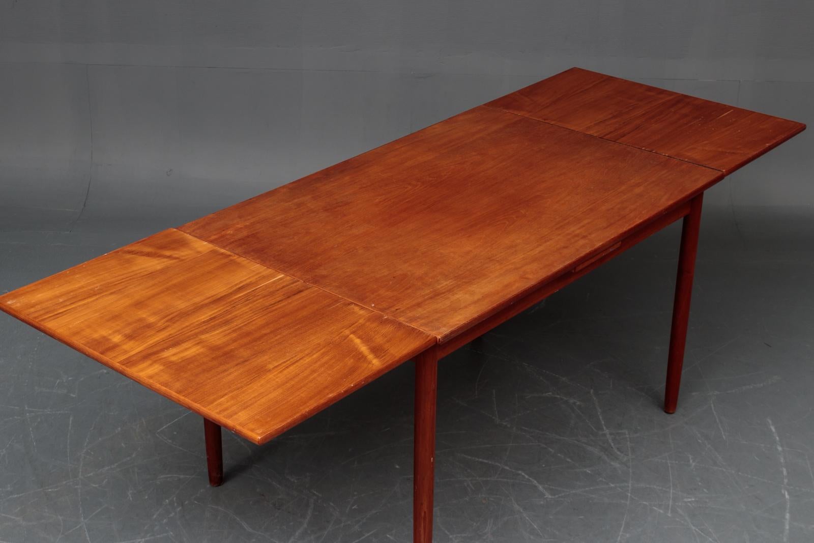 Danish teak dining table with extensions for additional seating.
