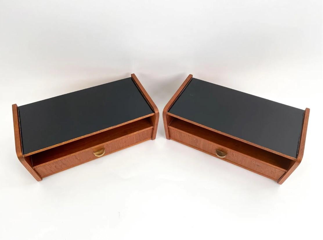 Pair of single-drawer floating nightstands or wall shelves, with black painted tops and brass drawer pulls. Danish, mid-century. 