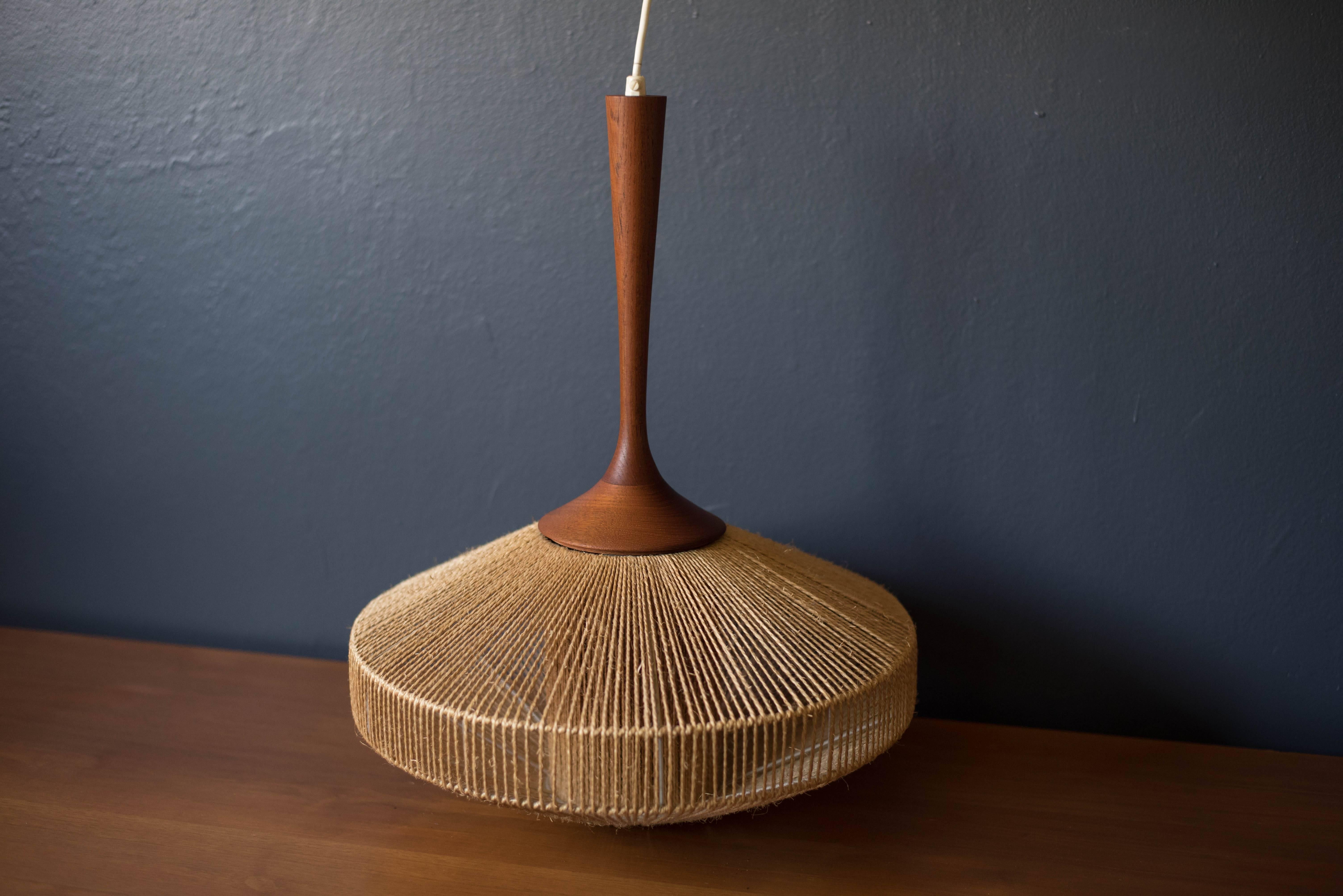 Mid-Century Modern pendant light by Fog and Morup, circa 1960s. This piece displays a unique symmetrical shape wrapped in jute with a sculpted teak stem.
