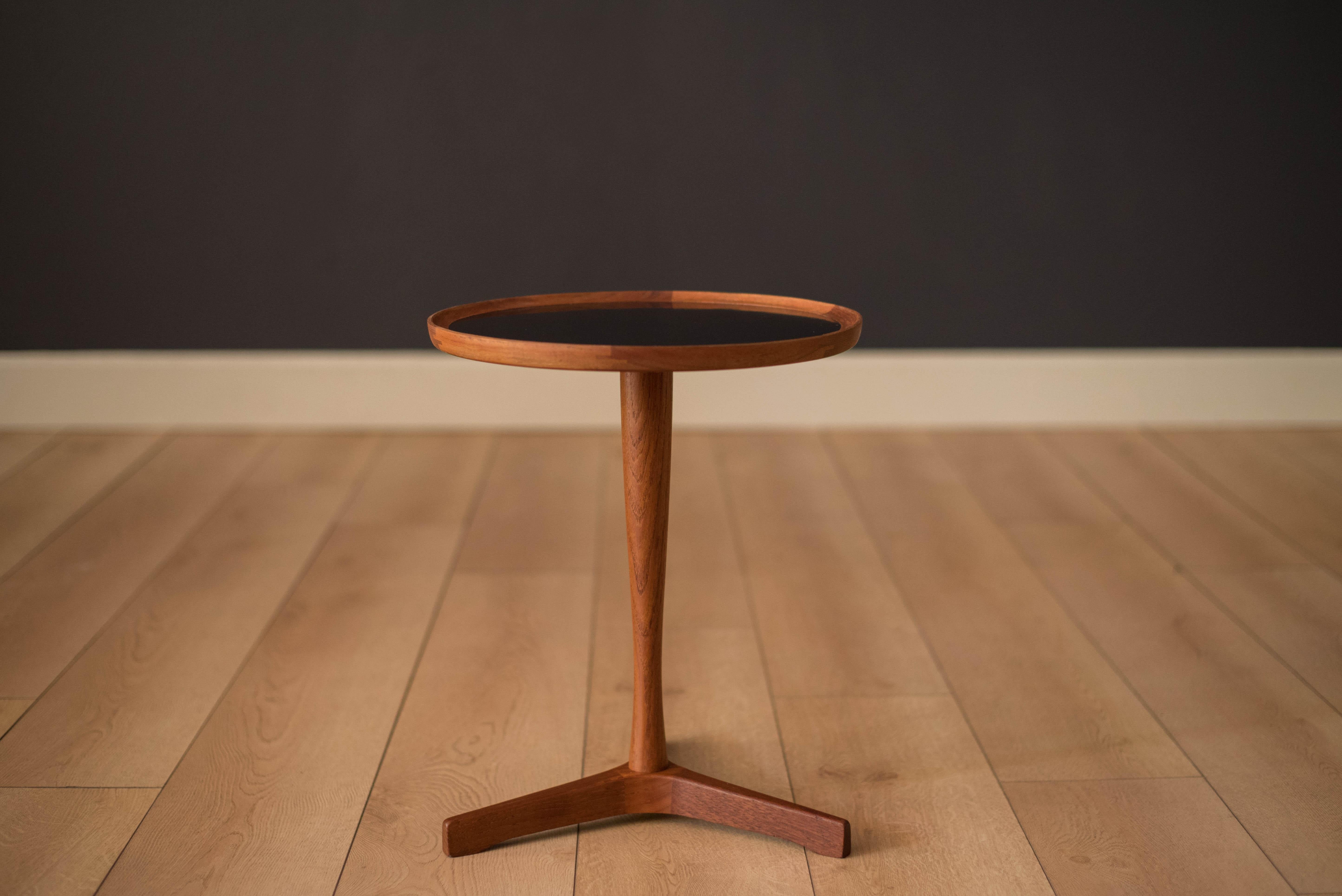 Mid-Century Modern side table designed by Hans C. Andersen, Denmark. This piece has a black laminate inlaid top and a solid teak pedestal base.
   