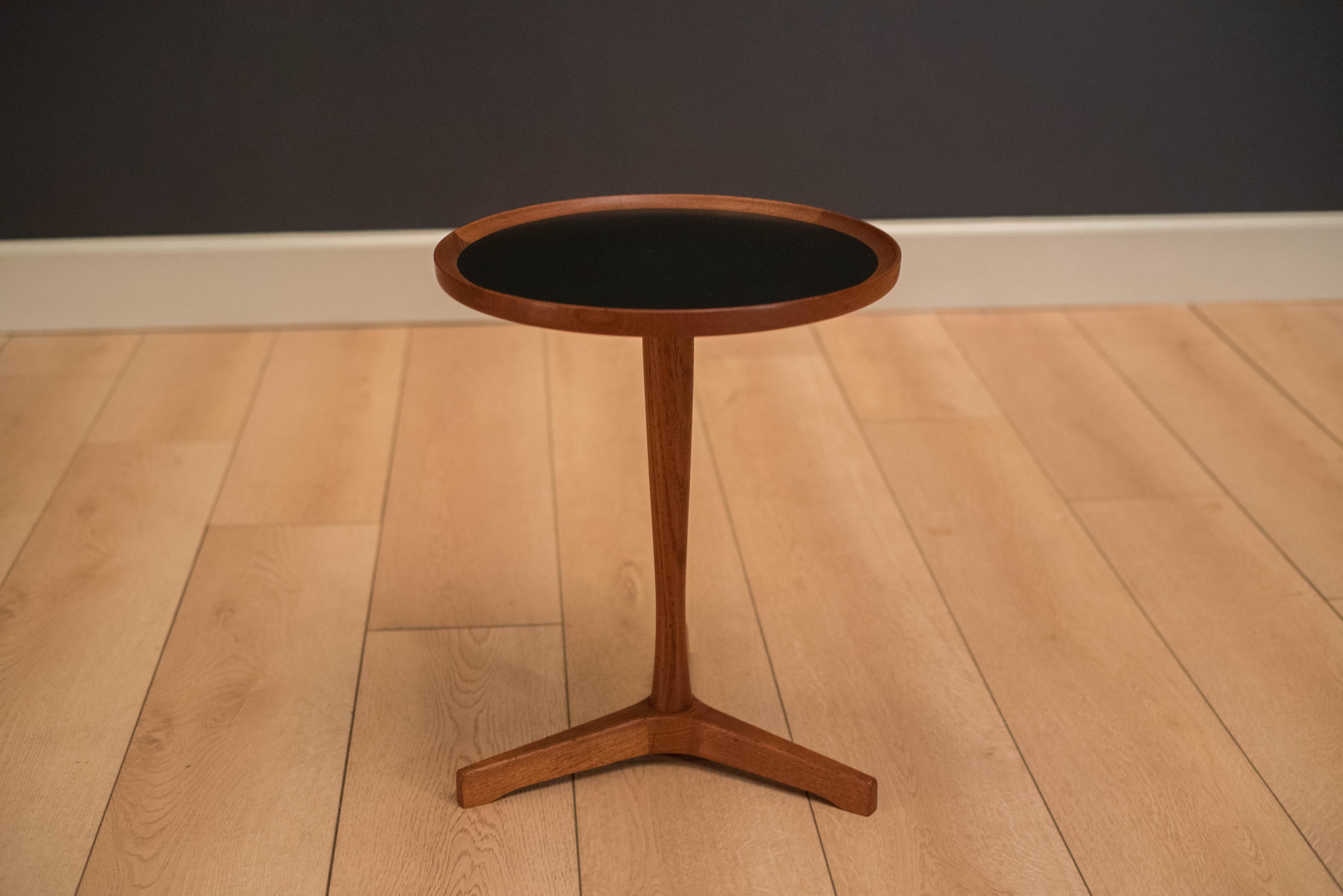 Mid-Century Modern side table designed by Hans C. Andersen for Artex. This piece has a black laminate inlaid top and a solid teak pedestal base.
 