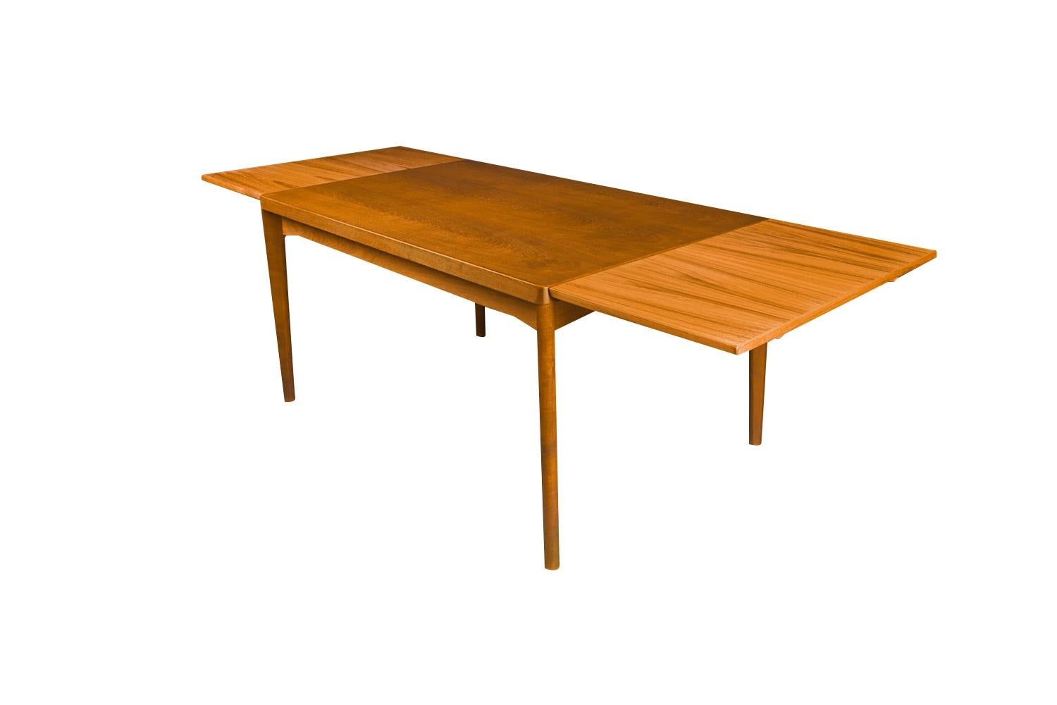 Exceptional Danish Modern teak extension dining table designed by Henning Kjaernulf for Vejle Stole og Møbelfabrik. With an initial large footprint, this table can also offer a generous space and double in size once its draw leaves are extended.