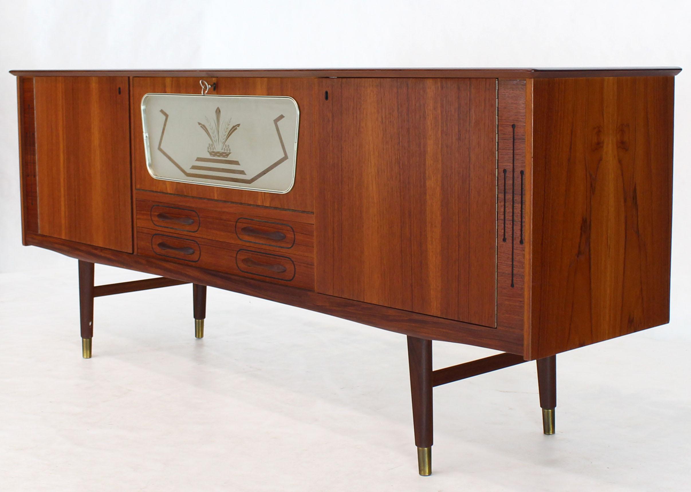 Danish Mid-Century Modern teak credenza with deco drop down door compartment. Beautiful polished aluminum frame detail. Arne Vodder design looking piece.