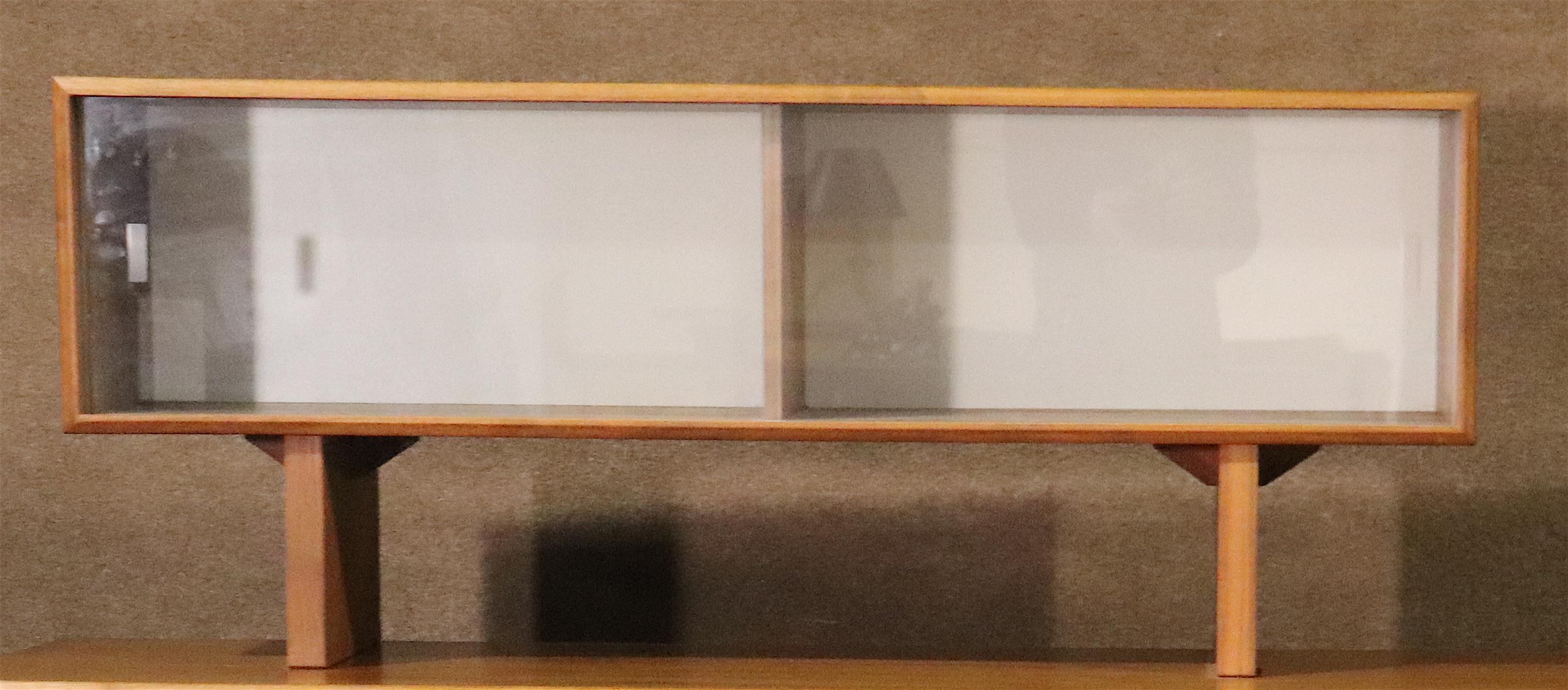 Armoire danoise moderne du milieu du siècle avec portes coulissantes en verre. Bois de teck avec dos blanc. Idéal pour le rangement dans le salon.
Veuillez confirmer le lieu NY ou NJ