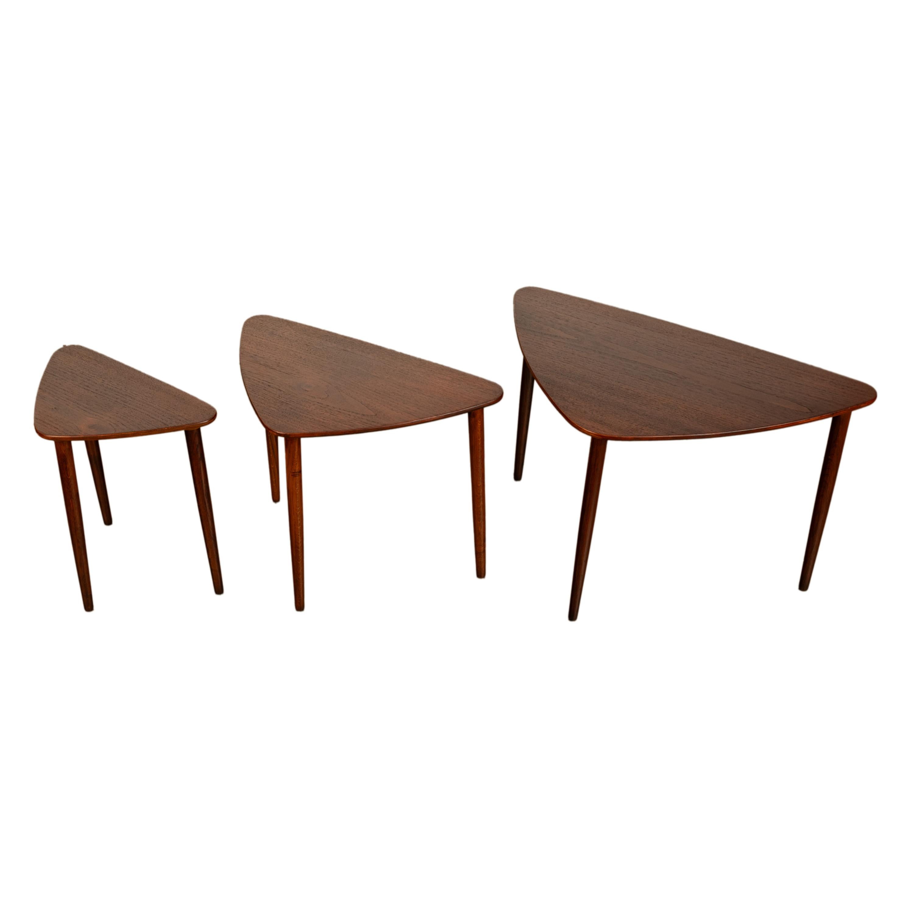 A good set of three Danish Mid Century Modern teak 'Guitar Pick' nest of tables, by Mogens Kold Mobelfabrik, circa 1960.
Three guitar pick shaped MCM tables of graduating size with gently tapering legs. The smallest table has the maker's label to