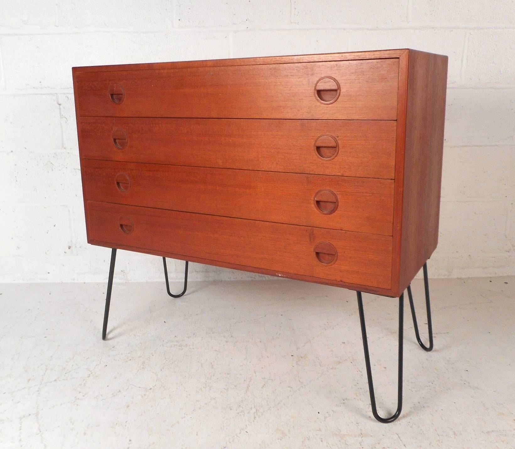 This vintage modern chest of drawers sits on top of four metal hairpin legs adding a unique quality to an already stunning piece. There is plenty of room for storage within its four large drawers with recessed ellipse pulls on each side. A handsome