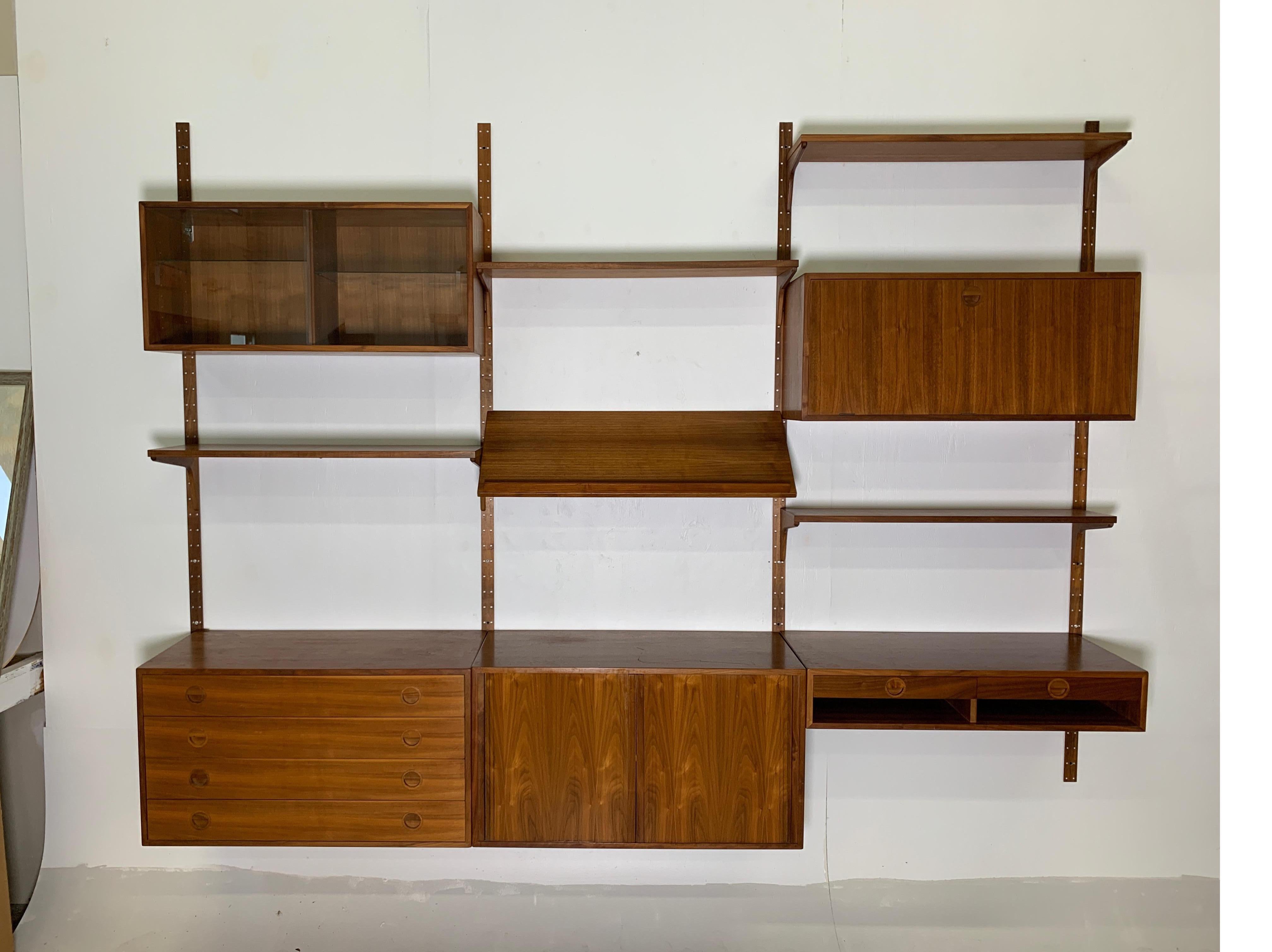 A beautiful and functional teak wall unit, produced by HG Furniture (Hansen and Guldborg) and designed by Rud Thygesen and Johnny Sorensen, Denmark, 1960s. With four wall-mounted uprights (steel with teak veneer), four large cabinets (one with four