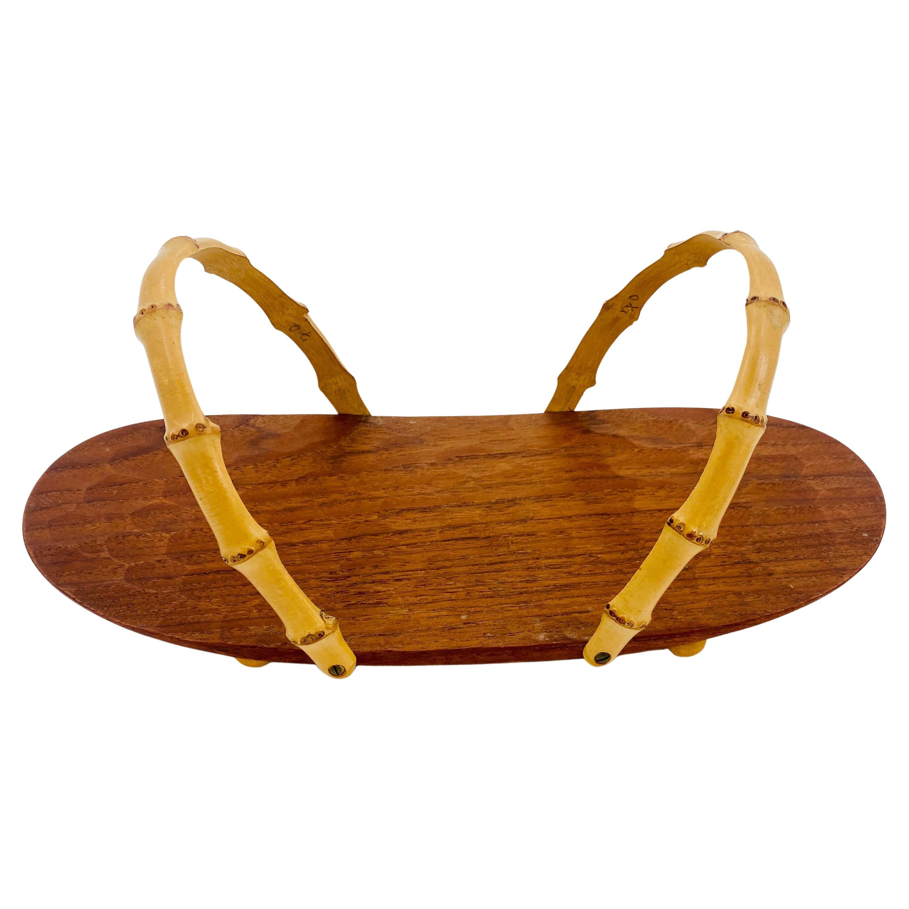 Scandinavian Mid-Century Modern Bread Basket or Napkin Tray in Teak With Bamboo Handles.
This rare teak serveware is made in teak and is marked underneath 