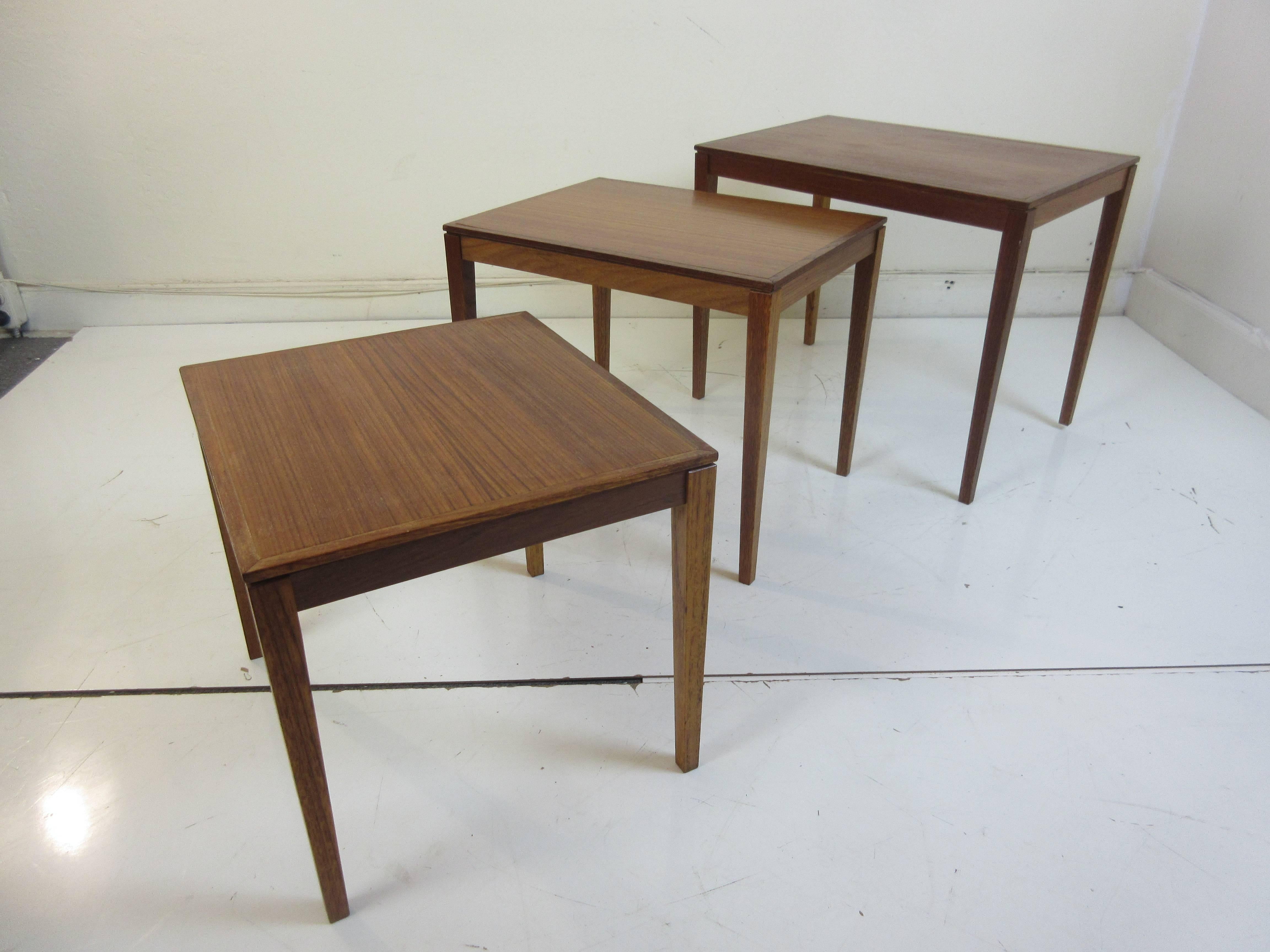 Danish teak nesting tables in three sizes with all fitting under the largest size. Legs are solid teak with a veneered top. Legs detach for easy shipping.