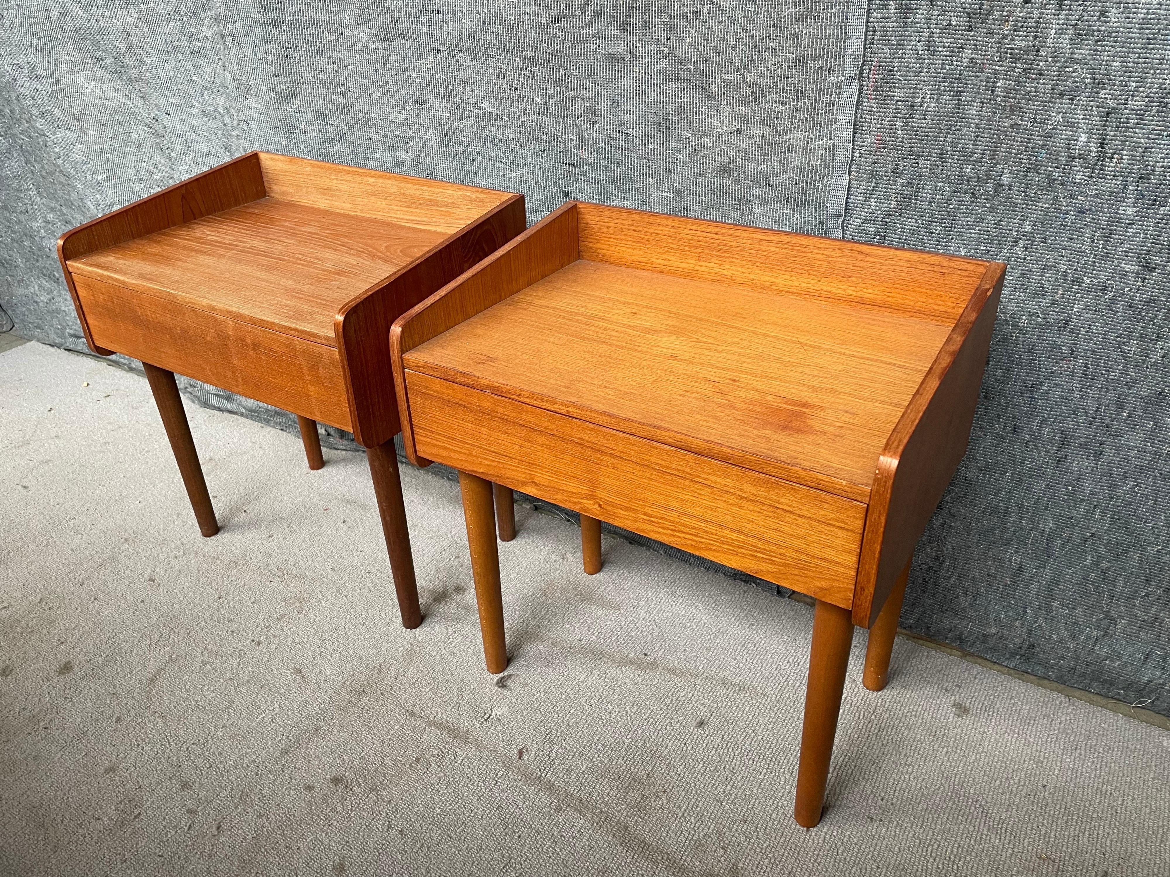 Handsome pair of Danish modern teak midcentury nightstands. A single pullout drawer provides storage for items.