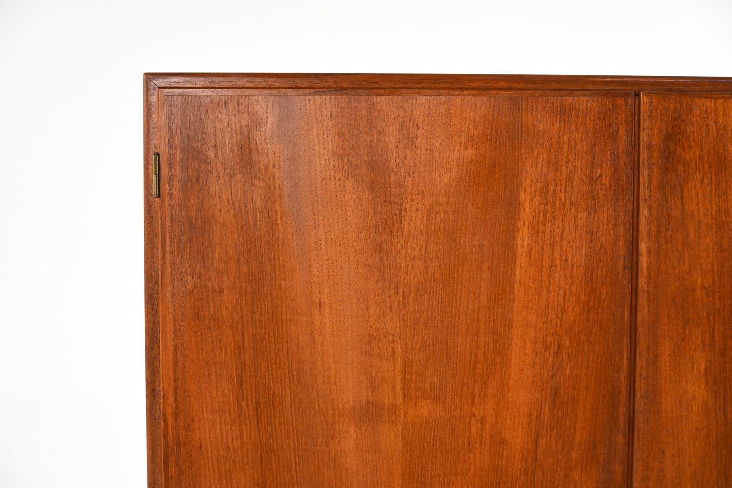 A rare wardrobe or tall storage cupboard in teak veneer, with seven adjustable maple shelves, two removable drawers, and a rounded tapered oak base. Designed by Børge Mogensen for Søborg Møbelfabrik c. 1950's. Key included.