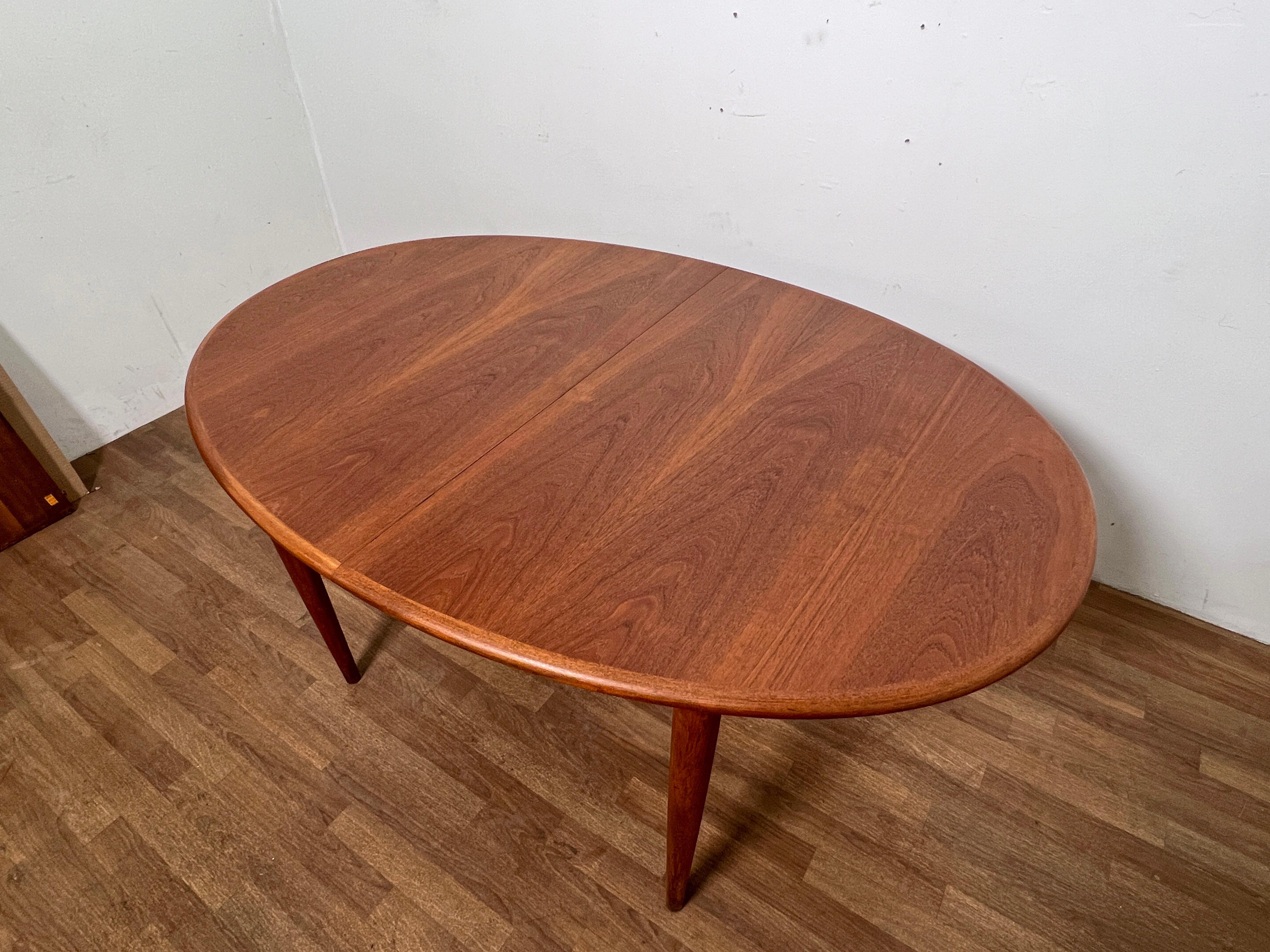 Danish teak oval dining table by Gudme, circa 1960s.   Includes two 19