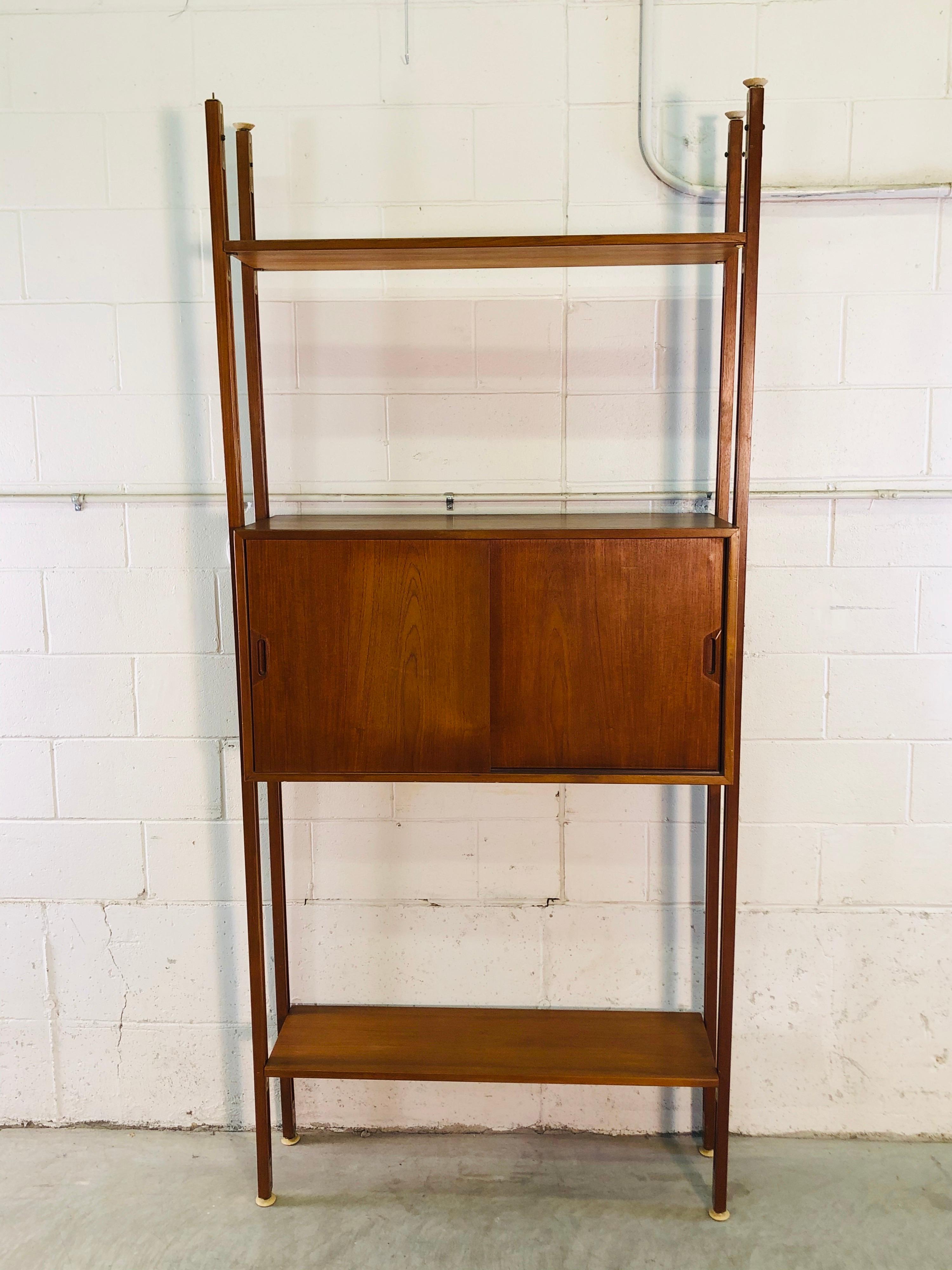 Vintage 1960s Danish teak room divider wall unit. The room divider is fully adjustable and can be configured any way you want. Comes with two shelves and a cabinet. Max adjustment height is about 95” H. No marks.
