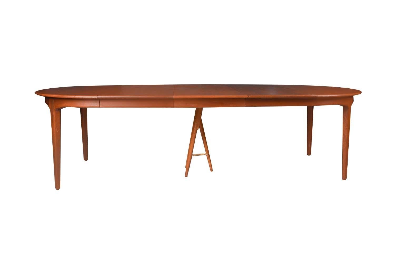 Magnifique grande table à manger ronde/ovale extensible en teck danois du milieu du siècle dernier, modèle 62, créée par le célèbre designer Henning Kjaernulf pour Soro Stolefabrik, vers les années 1960. Le plateau en teck, richement grainé, repose