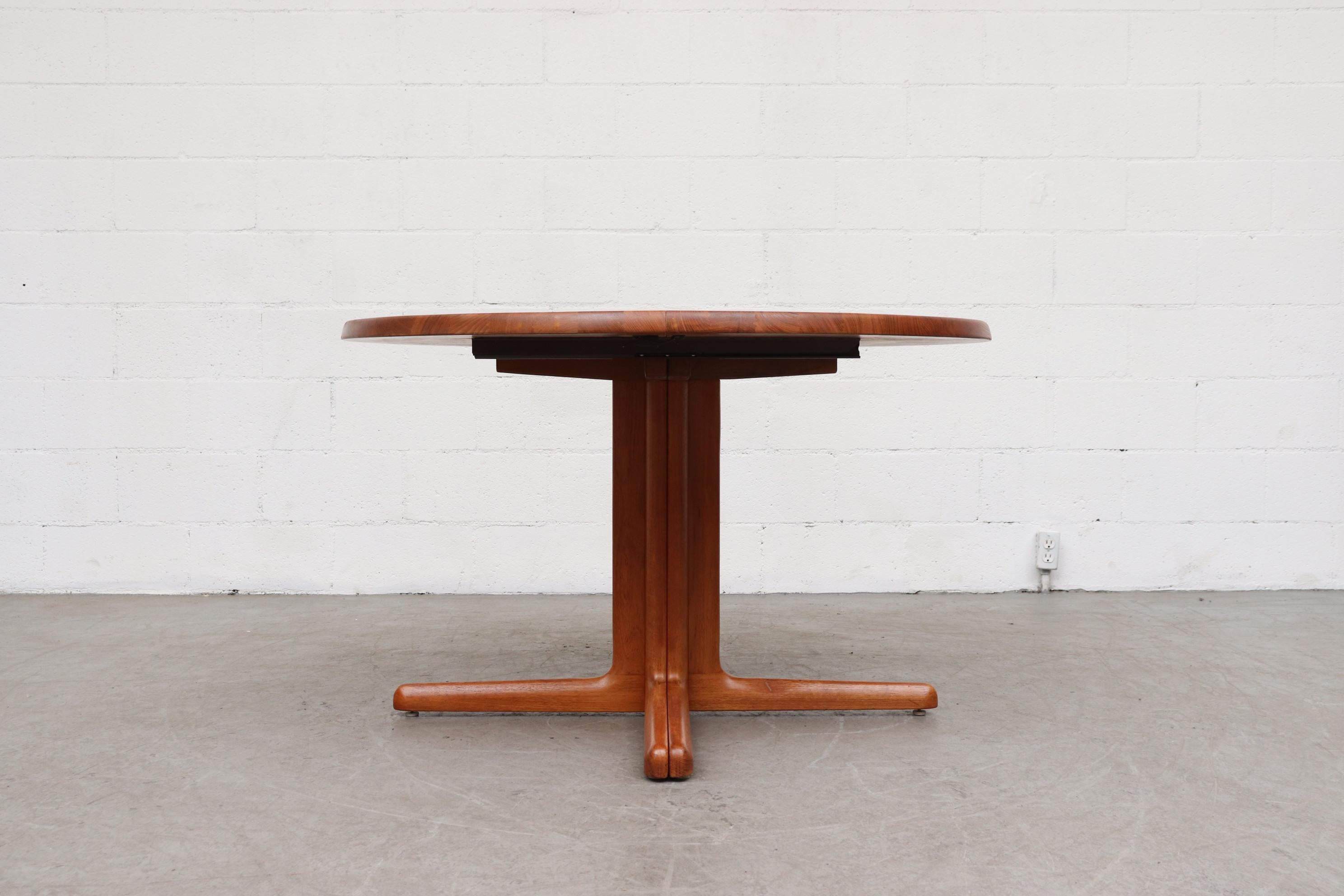 NiEls Moller for Gudme Mobelfabrik (attributed) solid teak Danish dining table round to oval dining table with 2 leaves. The leaves are hollow, but the round fixed top is solid. Pedestal base splits to 2 feet. Lightly refinished. In original