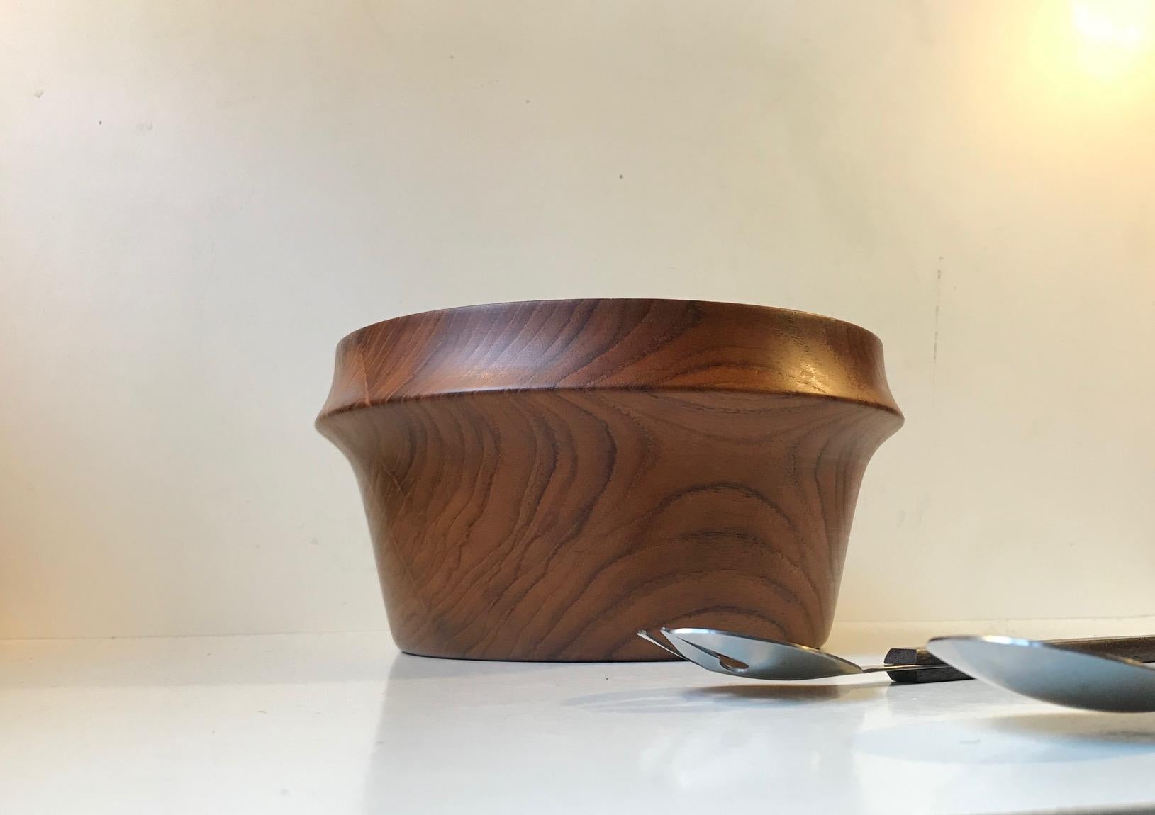 Large hand-turned wooden solid teak bowl from Wiggers, Denmark. It was designed and manufactured in the early 1960s. Wiggers collaborated with Illums Bolighus in Copenhagen during this period. The bowl comes with a salad serving set in rosewood and
