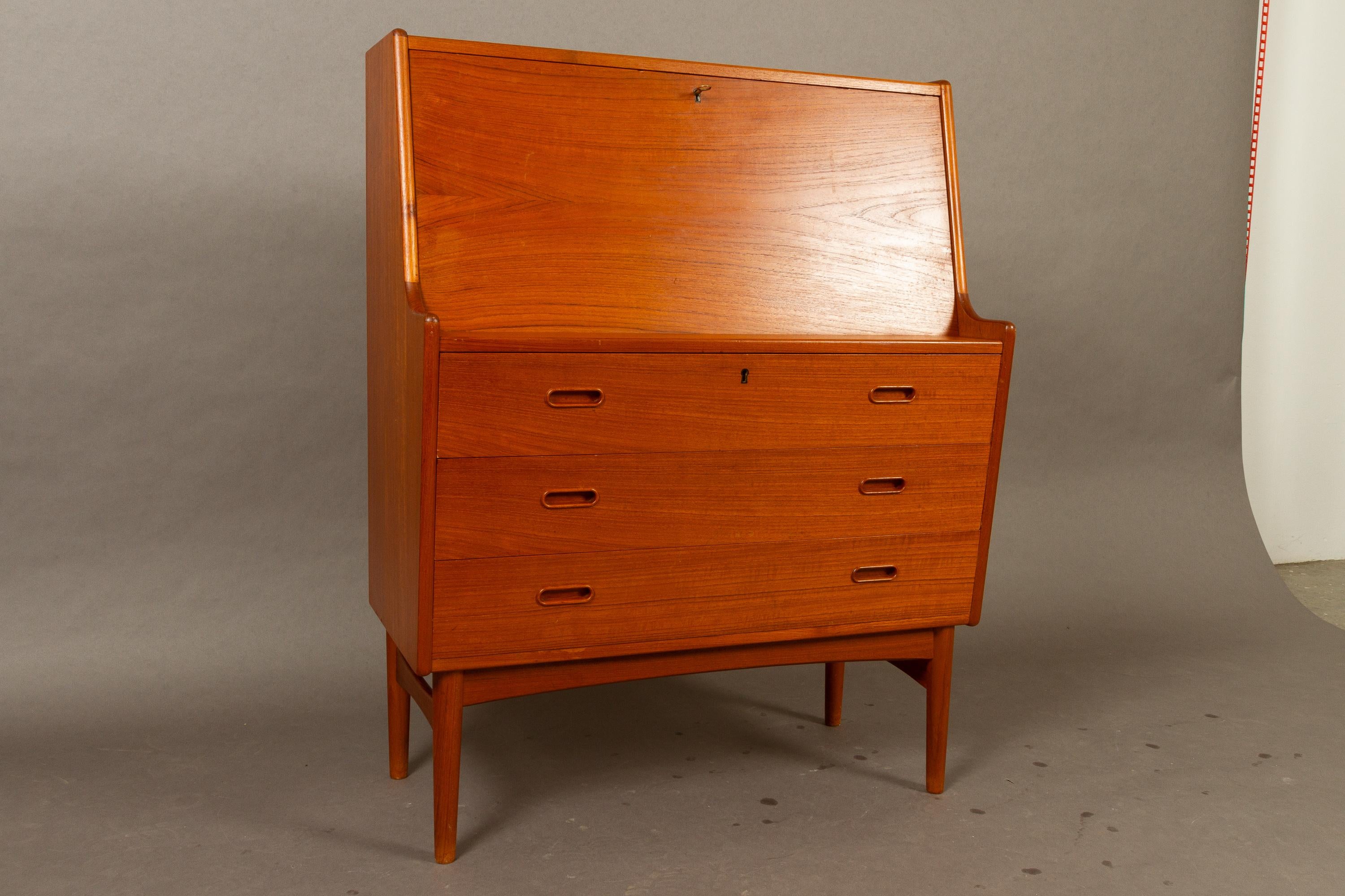 Danish teak secretaire model 37 by Arne Wahl Iversen for Vinde Møbelfabrik, 1960s
Classic Danish Mid-Century Modern secretary in teak with drop down tabletop with a lock. Doubles as a desk and chest of drawers. High of tabletop when dropped down is