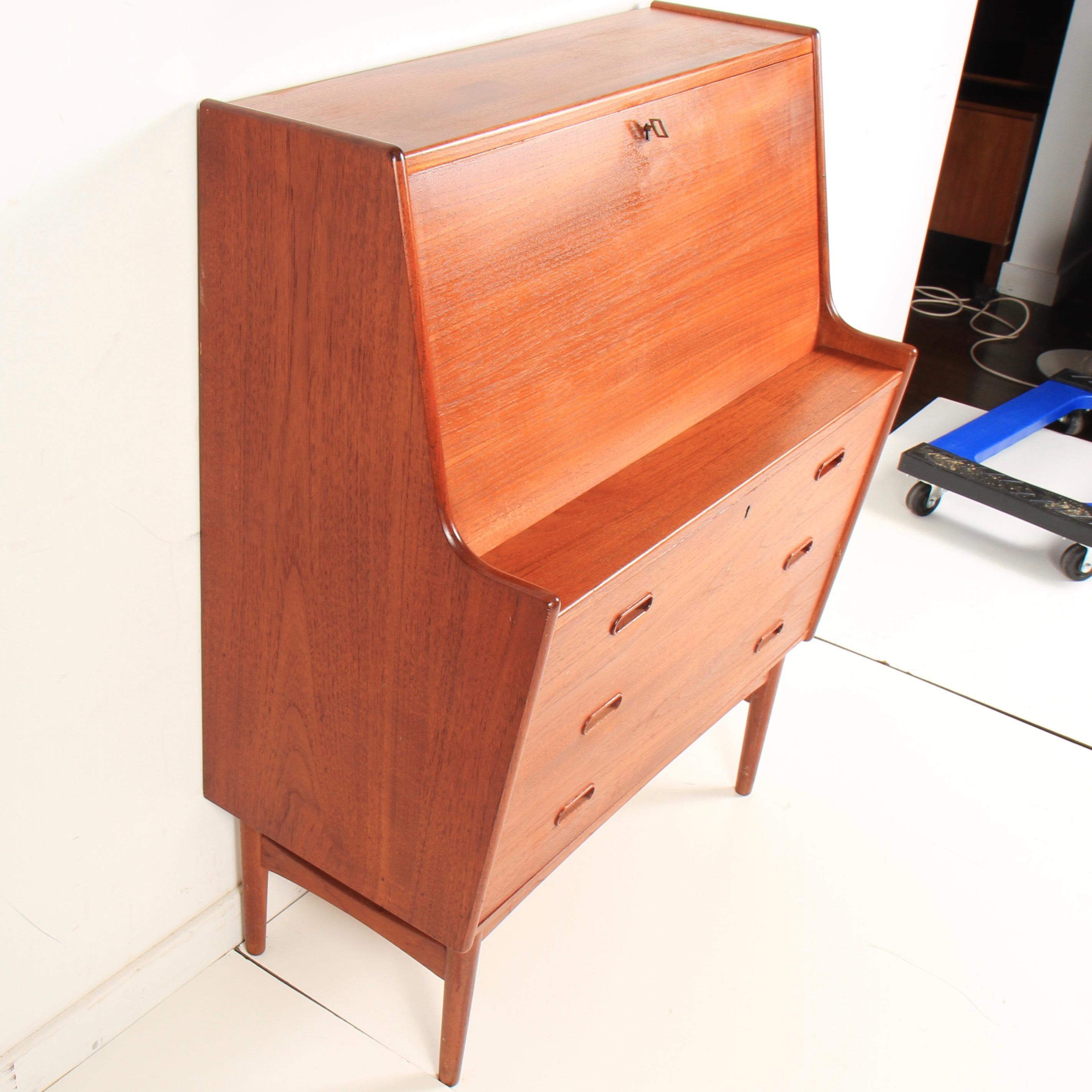 Danish drop front desk model 37 by Arne Wahl Iversen for Vinde Møbelfabrik, 1960s. Classic Danish Mid-Century Modern secretary in teak with drop down tabletop, and built in lamp. Both top and bottom drawers lock with original key included. Base is
