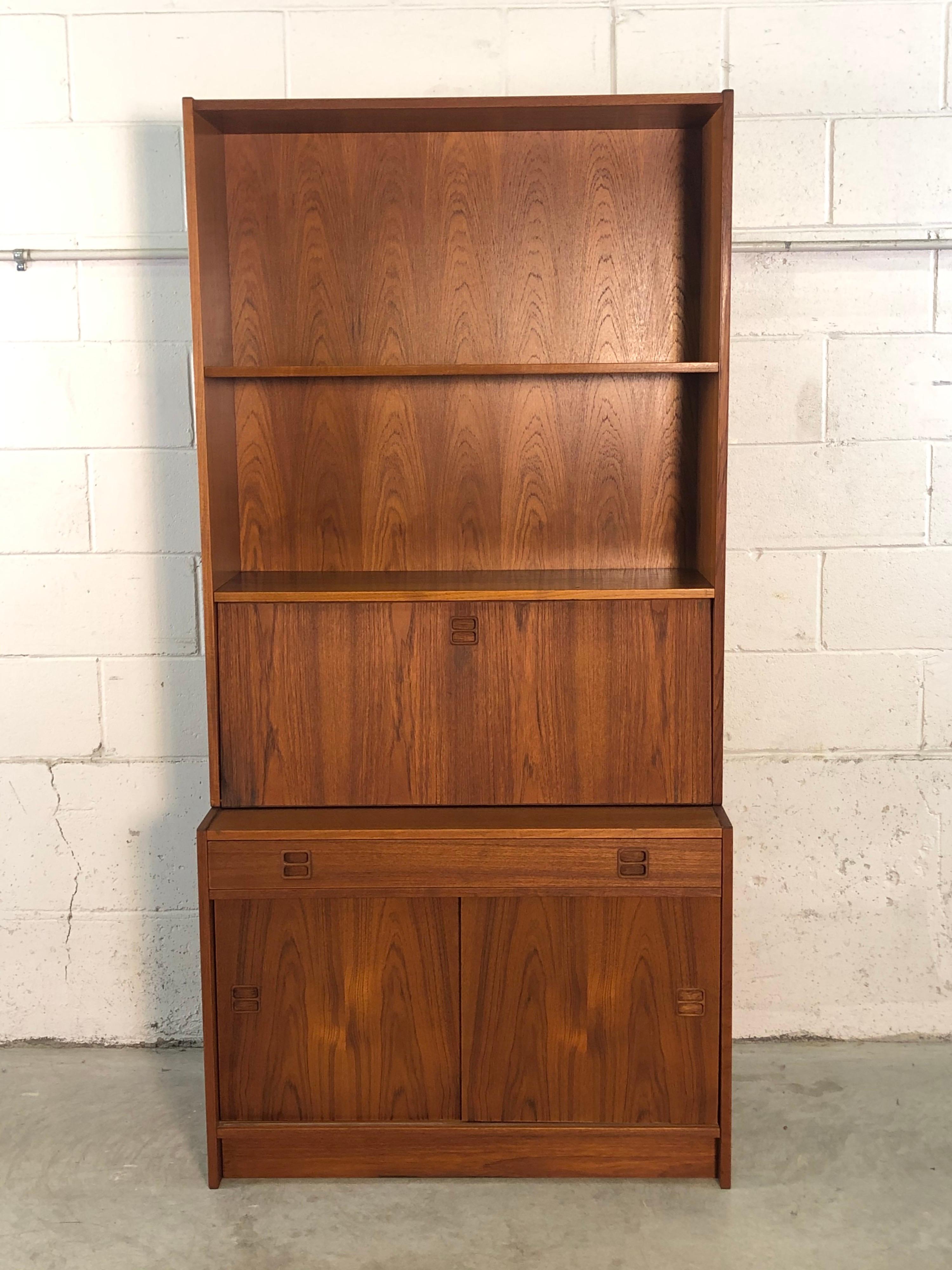 Vintage Danish teak secretary desk with shelving and a storage cabinet on the bottom. This versatile piece of furniture has a lot of storage options and can be used for different needs. Shelves can not be adjusted. Designed by Feldballes