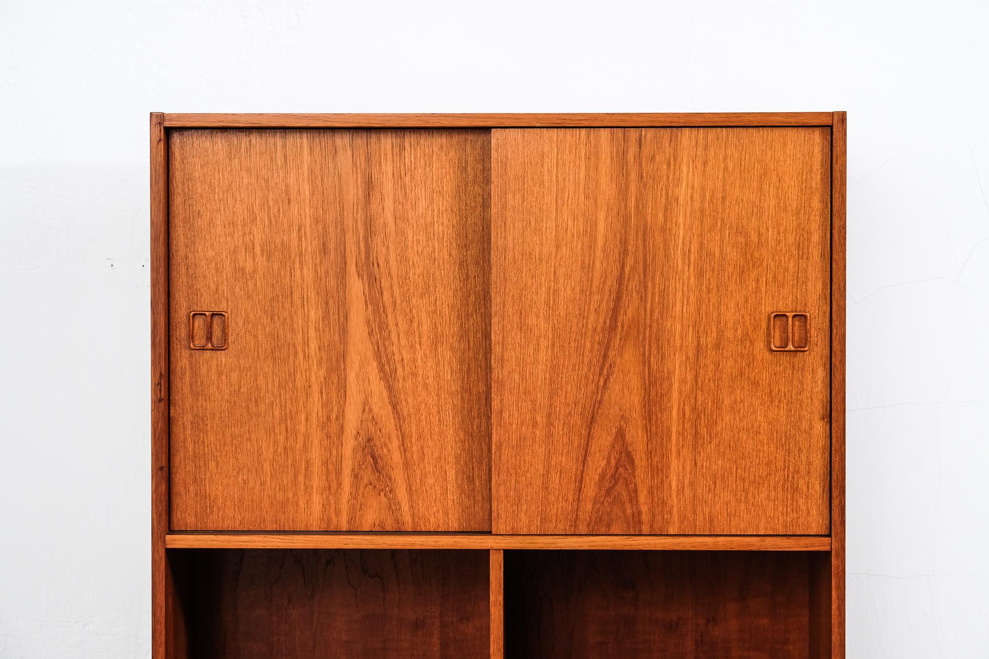 Danish teak shelf with two sliding doors. One shelf with green dividers used for LP records.