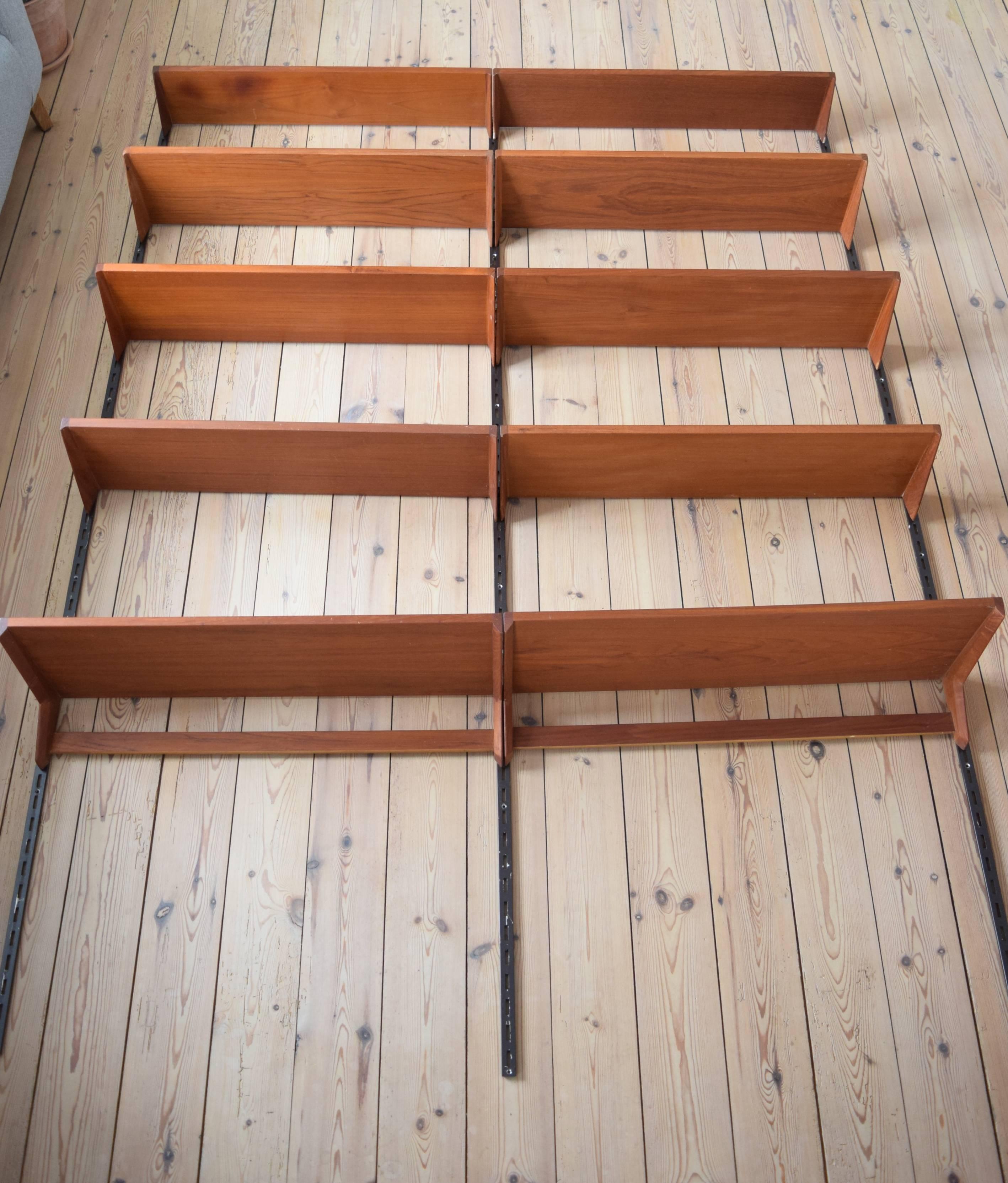 Set of ten teak shelves by Kai Kristiansen and manufactured by Feldballes Møbelfabrik, Denmark from the 1960s. This system comprises of eight height adjustable small shelves, two desk top shelves and three metal hanging rails. Apart from some marks