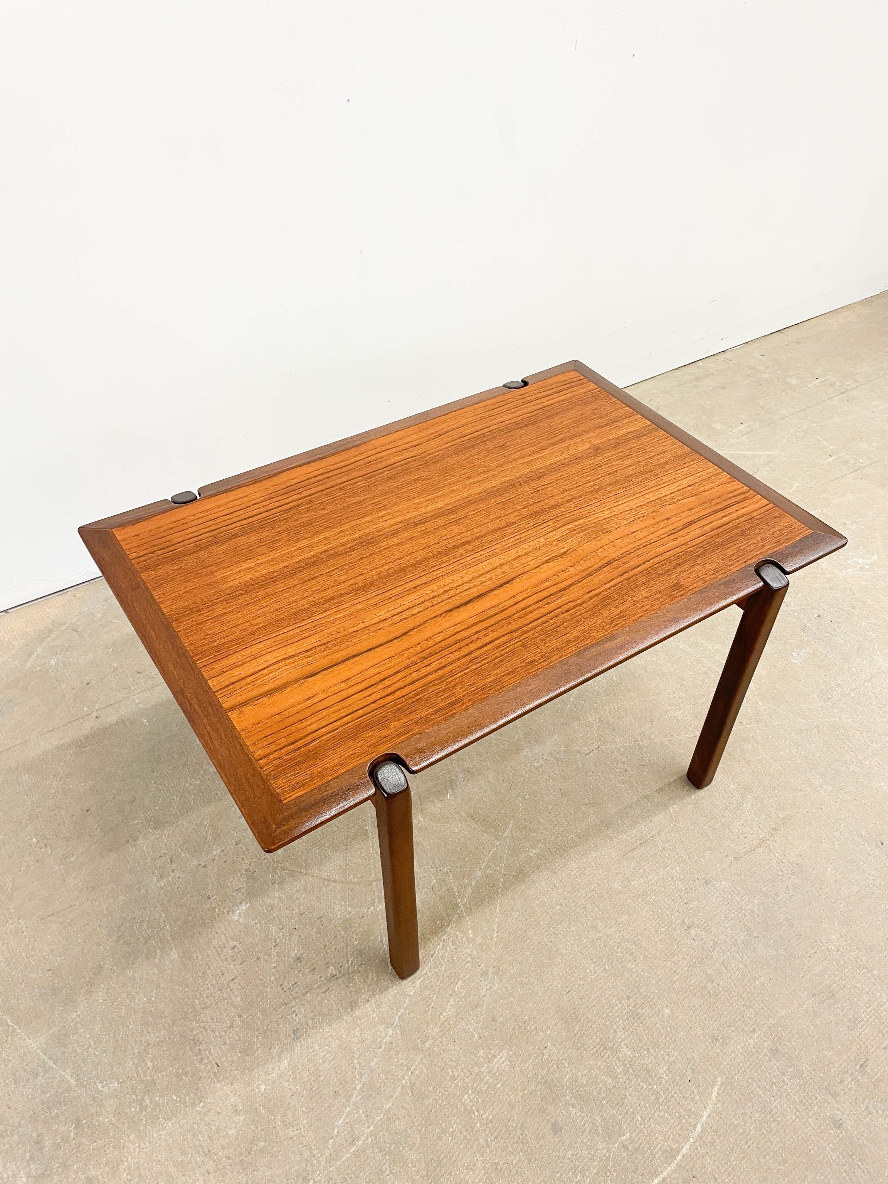 Beautiful teak grain side table with a sleek beveled edge perimeter made in Denmark. Great as a side, end or occasional table with a gorgeous Teak grain that shows through a clear lacquer finish. Very interesting profuile with the beveled knife edge