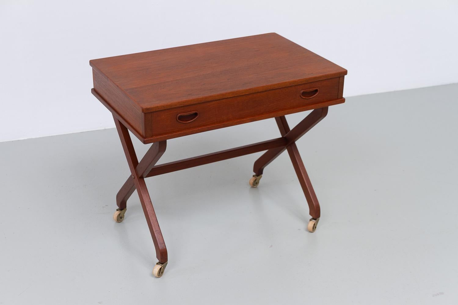 Danish Teak Side Table with Drawer, 1960s.

Lovely Scandinavian Mid-Century Modern side table on casters with scissor legs and wide drawer. The inside of the drawer is fitted smaller compartments, all made from Beech. Beautiful half blind dovetail