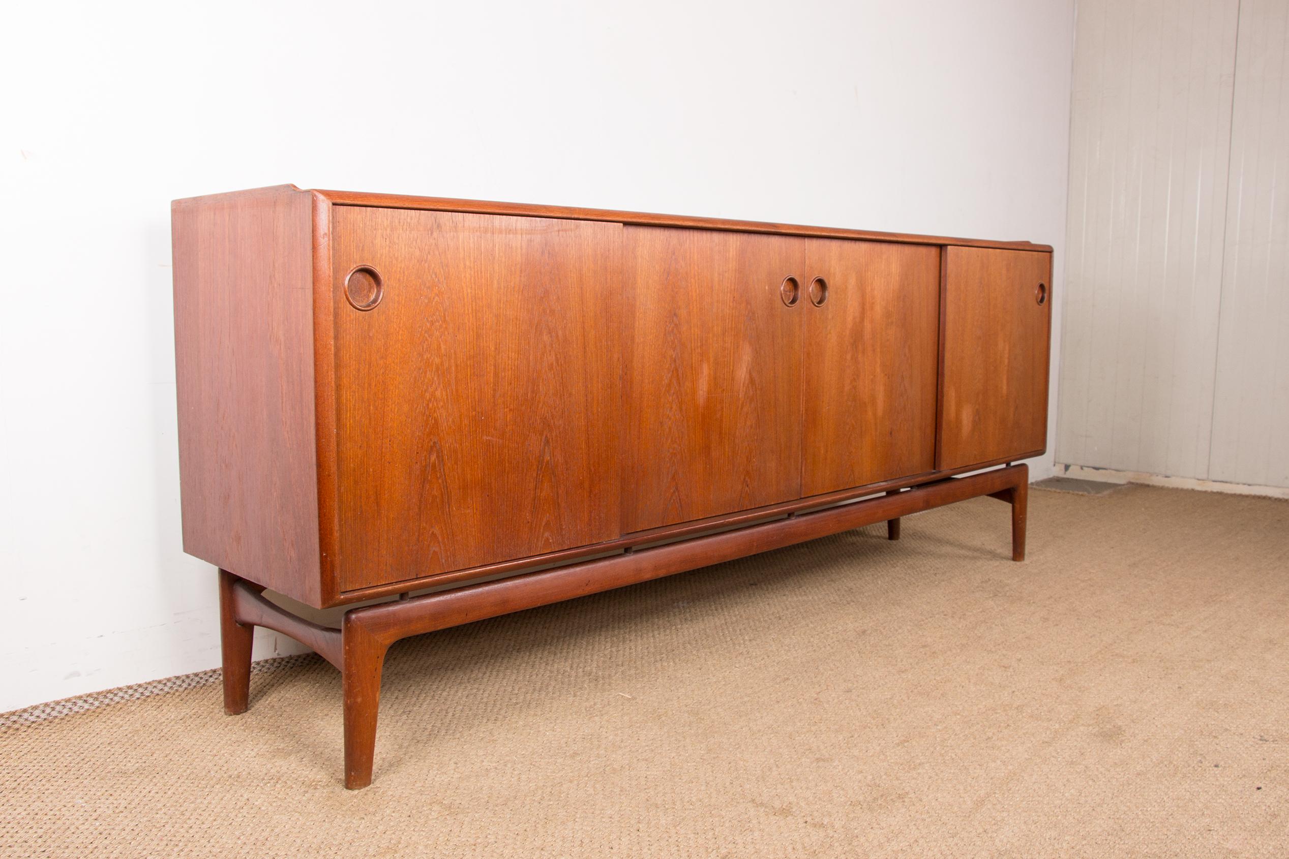 Superb Scandinavian sideboard that can be used as a Sideboard because it is veneered in teak on its rear side. 
4 sliding doors, the left door opens onto 6 interior drawers, the two middle doors open onto a very large shelf and the right door opens