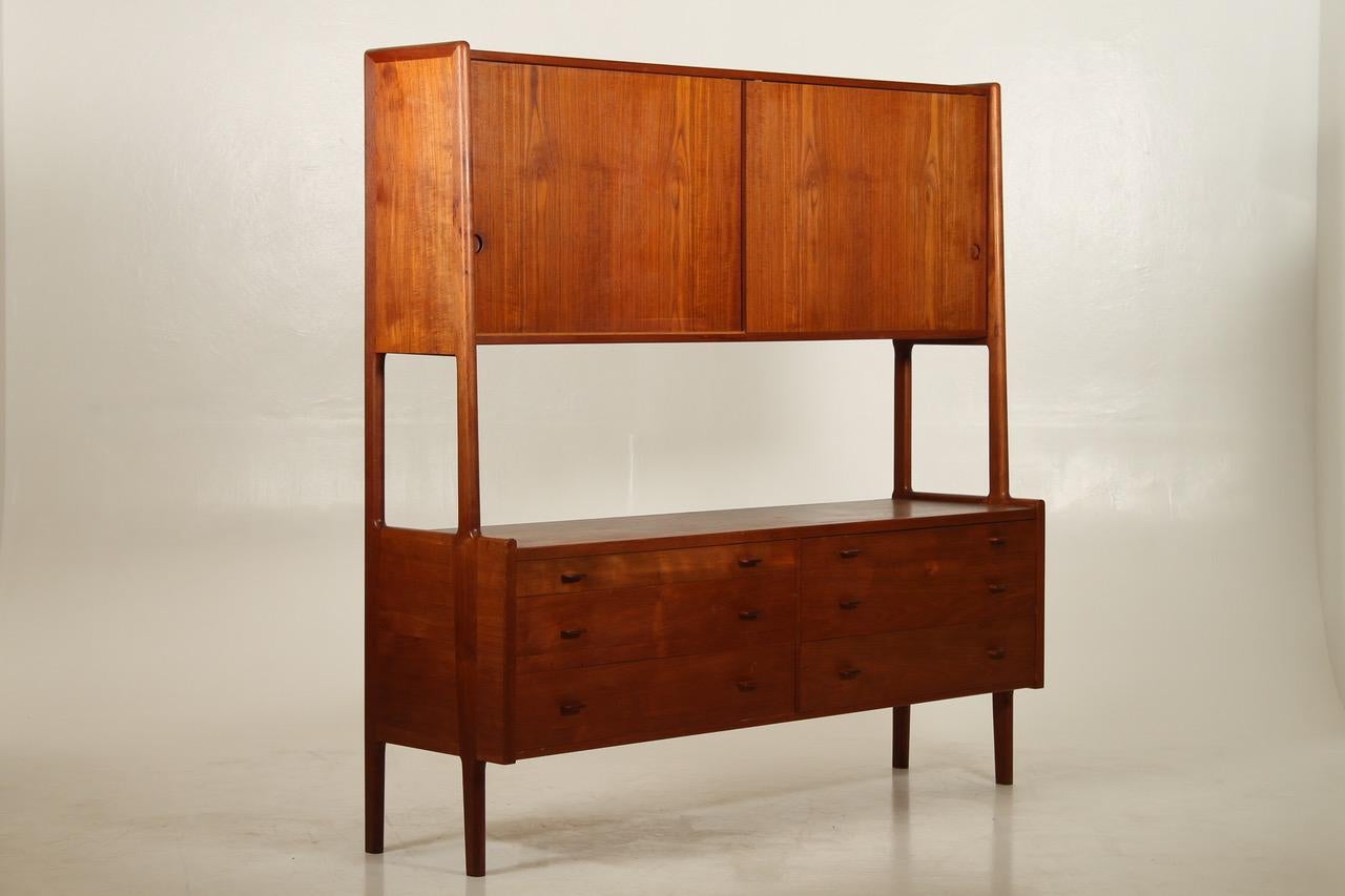 Danish teak sideboard by H. J. Wegner for Ry Møbler 1955. Model Ry 20.
Tall two-tiered teak highboard with six wide drawers and two cabinets with shelves. Rounded tapered legs. Inside of cabinets and drawers in light wood.
Beautiful golden teak