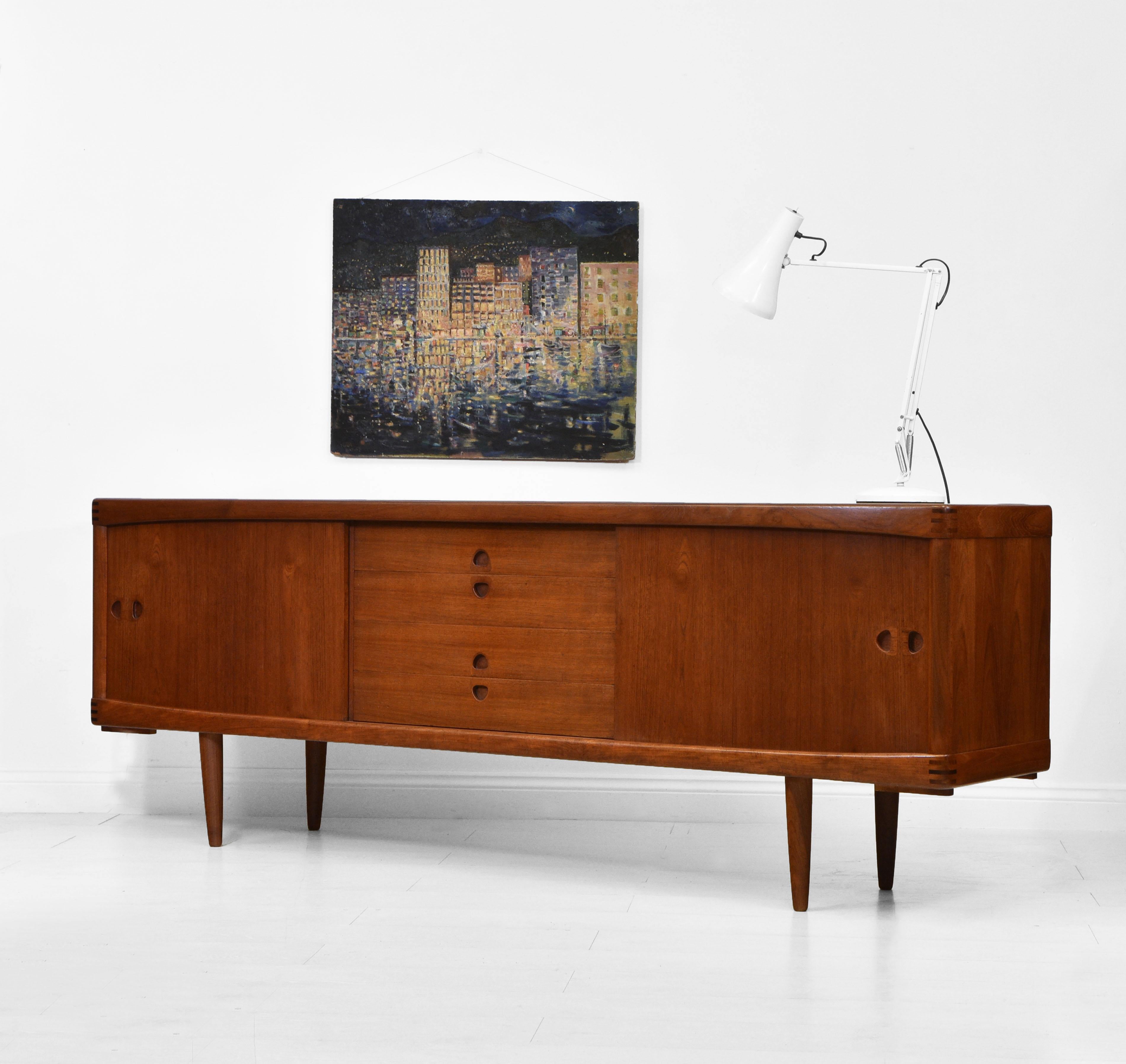 A Danish mid-century teak sideboard designed by Henry Klein for Bramin, Denmark. Circa 1960s.

A superbly designed sideboard with sculptured inset handles and rosewood finger joint detail to the corners. It has a lovely rich colour, and is in good