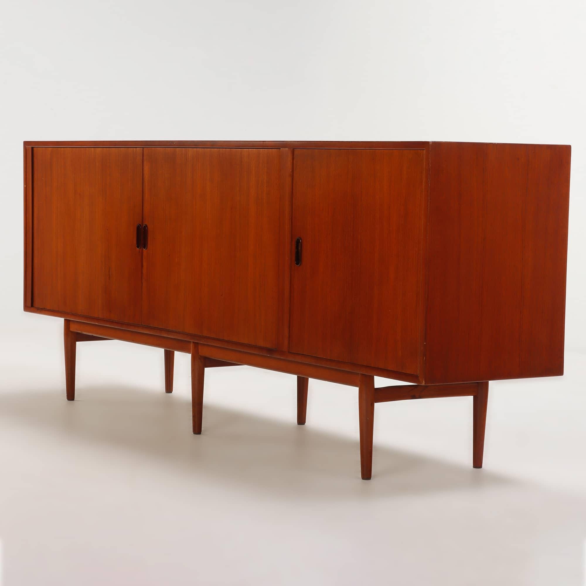 Diese Anrichte Modell 37 ist ein eindrucksvolles Beispiel für das dänische Mid-Century Modern Design und wurde um 1960 von Arne Vodder für Sibast Møbler entworfen. Das aus reich gemasertem Teakholz gefertigte Möbelstück verfügt über zwei der für