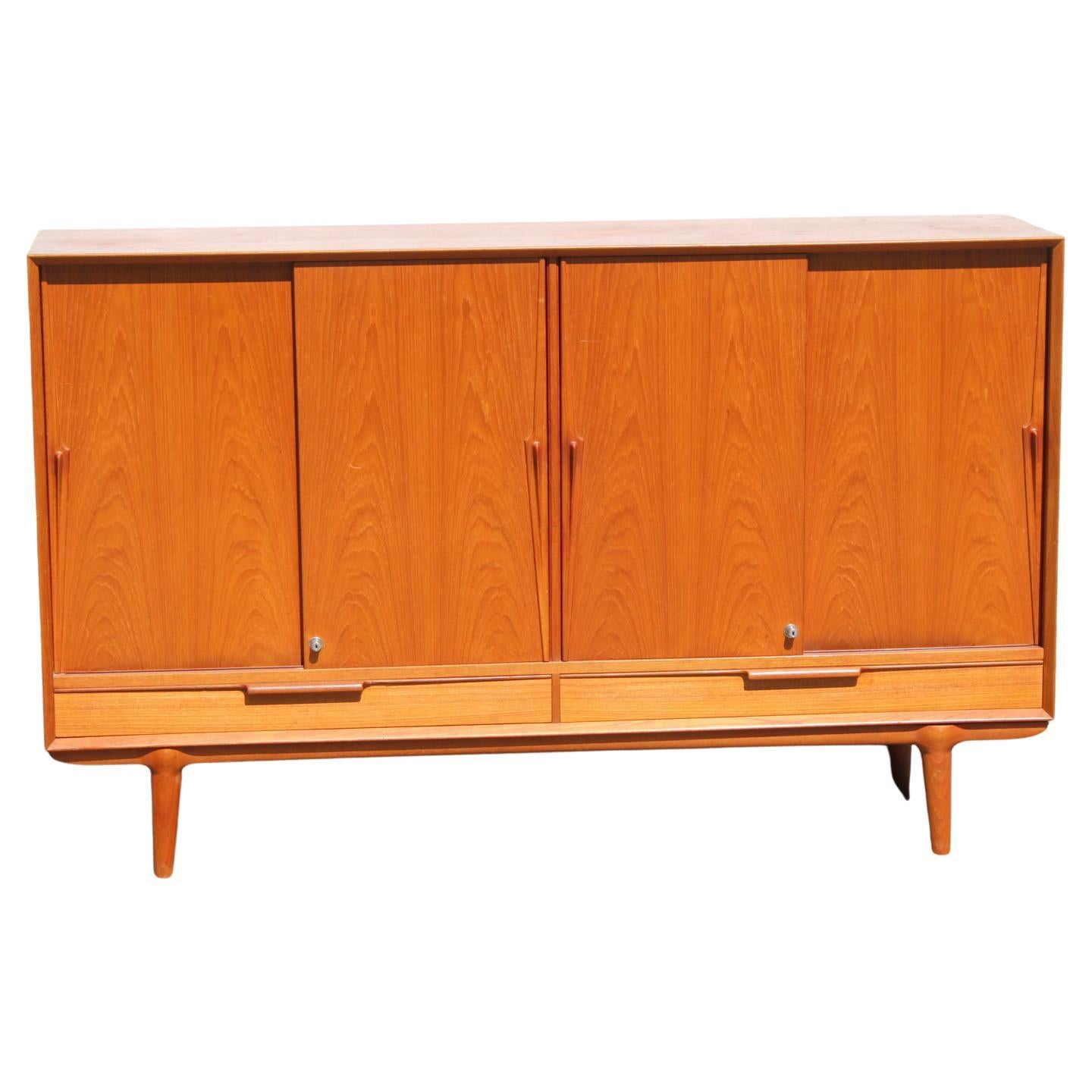 Danish teak sideboard from Omann Jun, 1960s

This elegant mid-century sideboard was made in Denmark in Omann Jun. The minimalist carcass stands on conical legs. The handles on the doors have a shape that is characteristic of the manufacturer.