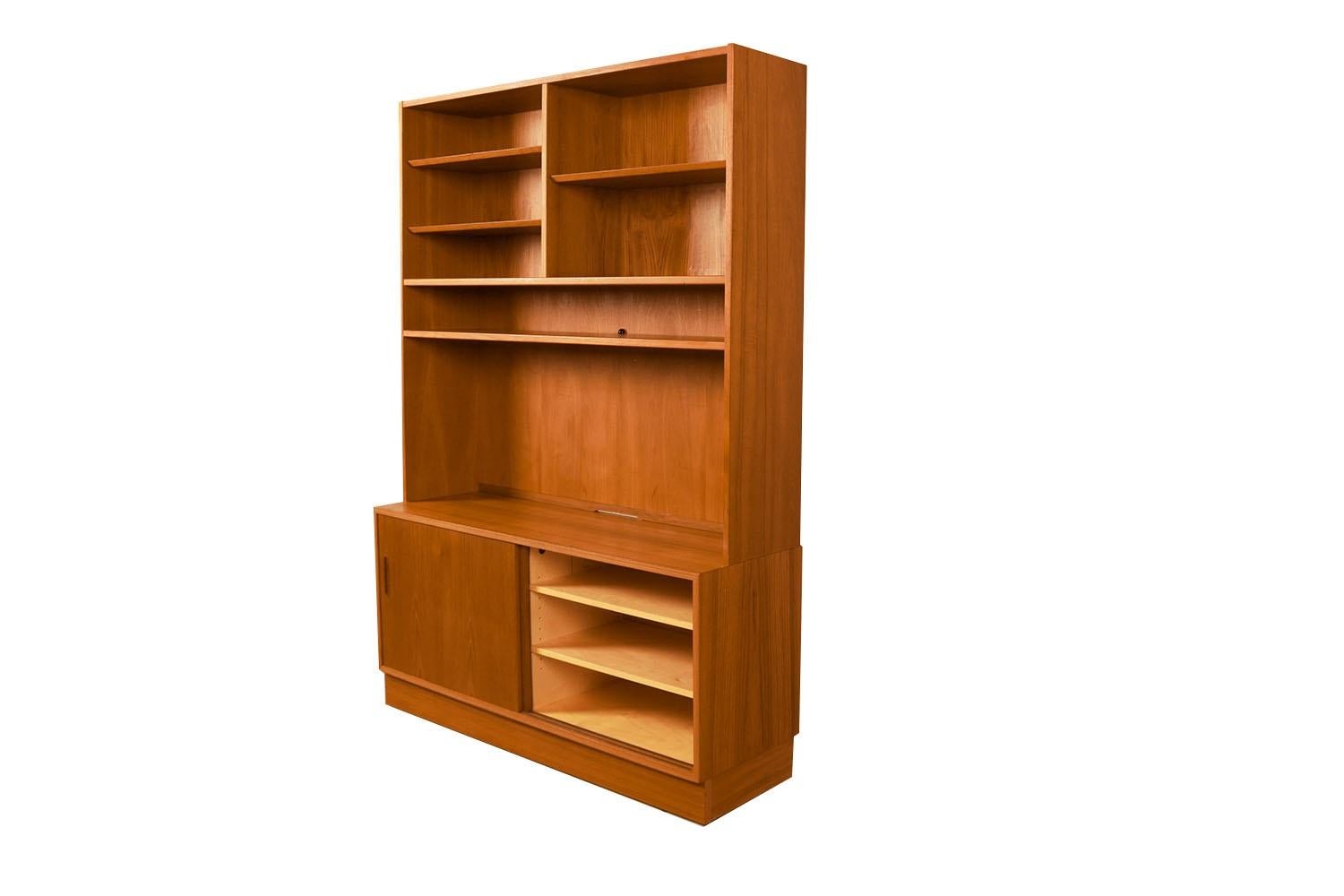 Fantastic Danish teak storage cabinet/ hutch by designer Poul Hundevad. This amazing vintage teak veneer storage cabinet/hutch features a two-piece hutch resting on a credenza base made in Denmark by designer Poul Hundevad. A beautiful Danish Modern