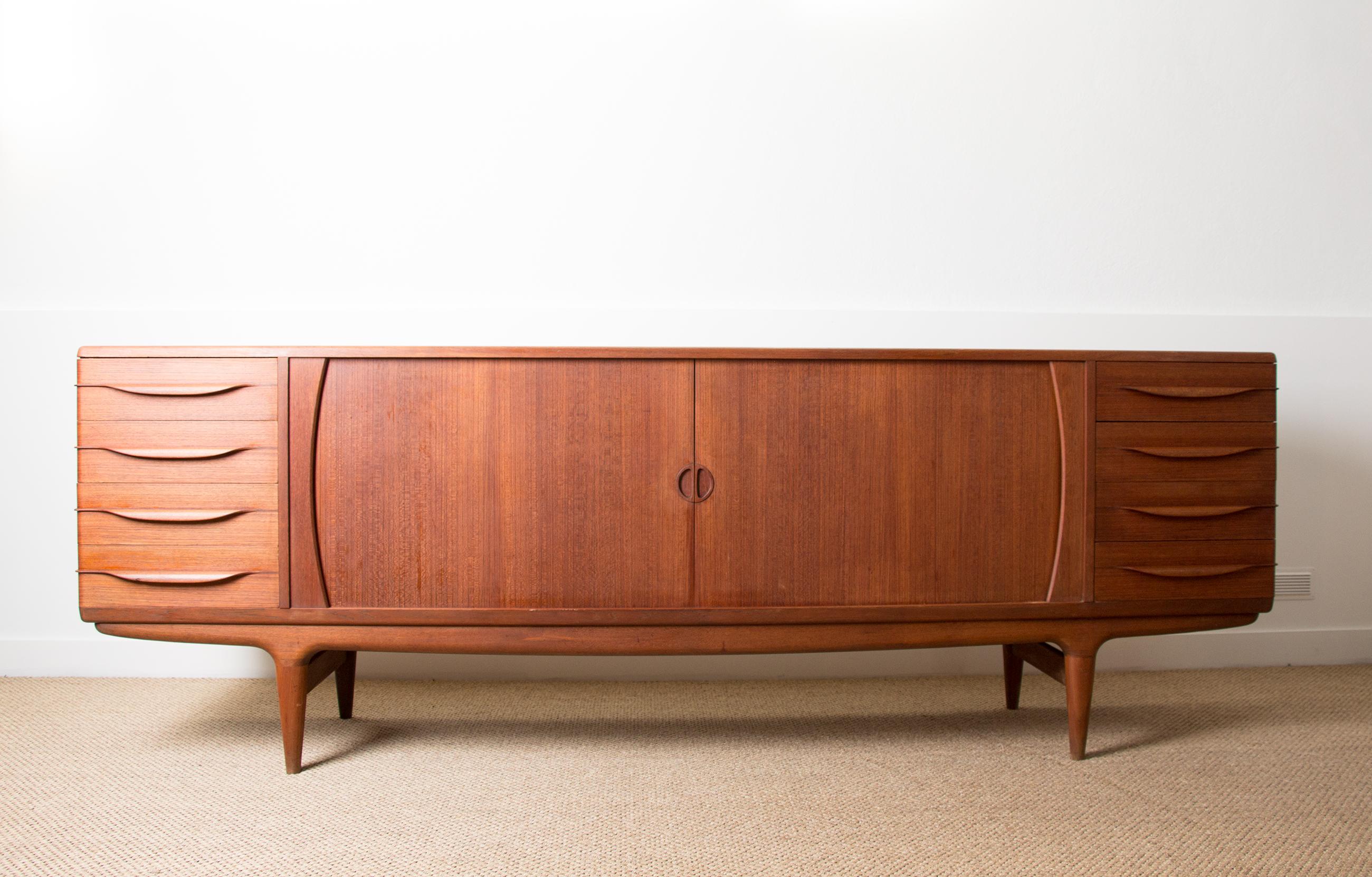 Superb Scandinavian sideboard made up of 2 x 4 drawers (with a cutlery under drawer on the top drawer) on the sides and two large curtain doors which open onto 4 shelves. Iconic piece of furniture by this Designer referenced at the Design Museum
