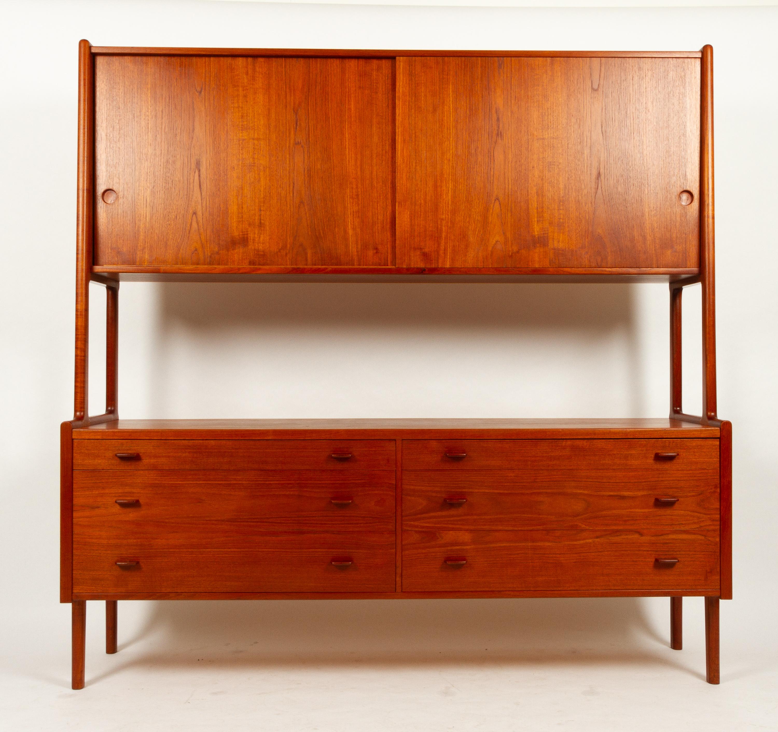 Danish Teak Sideboard by H. J. Wegner for Ry Møbler 1955. Model Ry 20.
Tall two-tiered teak highboard with six wide drawers and two cabinets with shelves. Rounded tapered legs. Inside of cabinets and drawers in light wood.
Beautiful golden teak