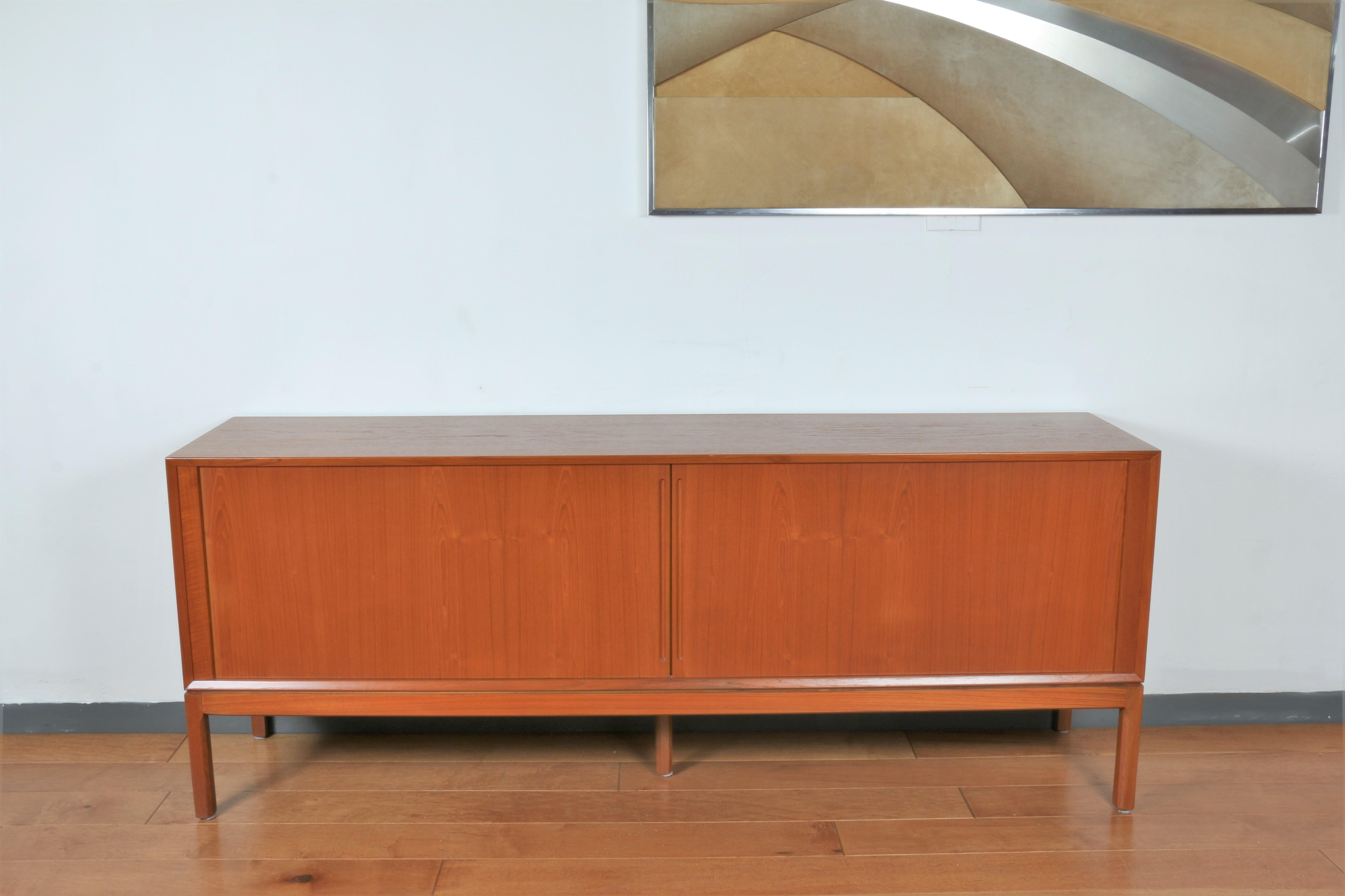 Danish modern teak credenza with tambour sideboard doors. The credenza is made with two sliding sideboards and two opening drawers on one side. This was made in 1960's and 
 is refurnished.