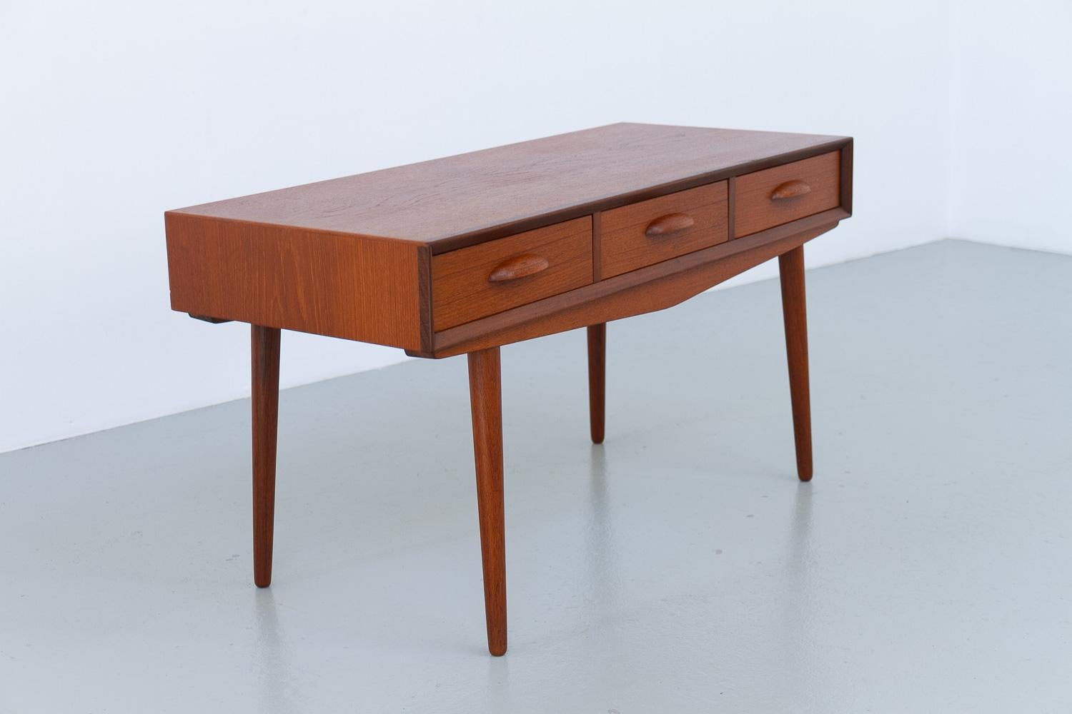 Buffet danois en teck à trois tiroirs, années 1960.

Petit buffet ou table console en teck The Modern Scandinavian Mid-Century Modern. 
Trois tiroirs avec poignées sculptées. Grands pieds ronds et effilés.

Des proportions élégantes et un grain et