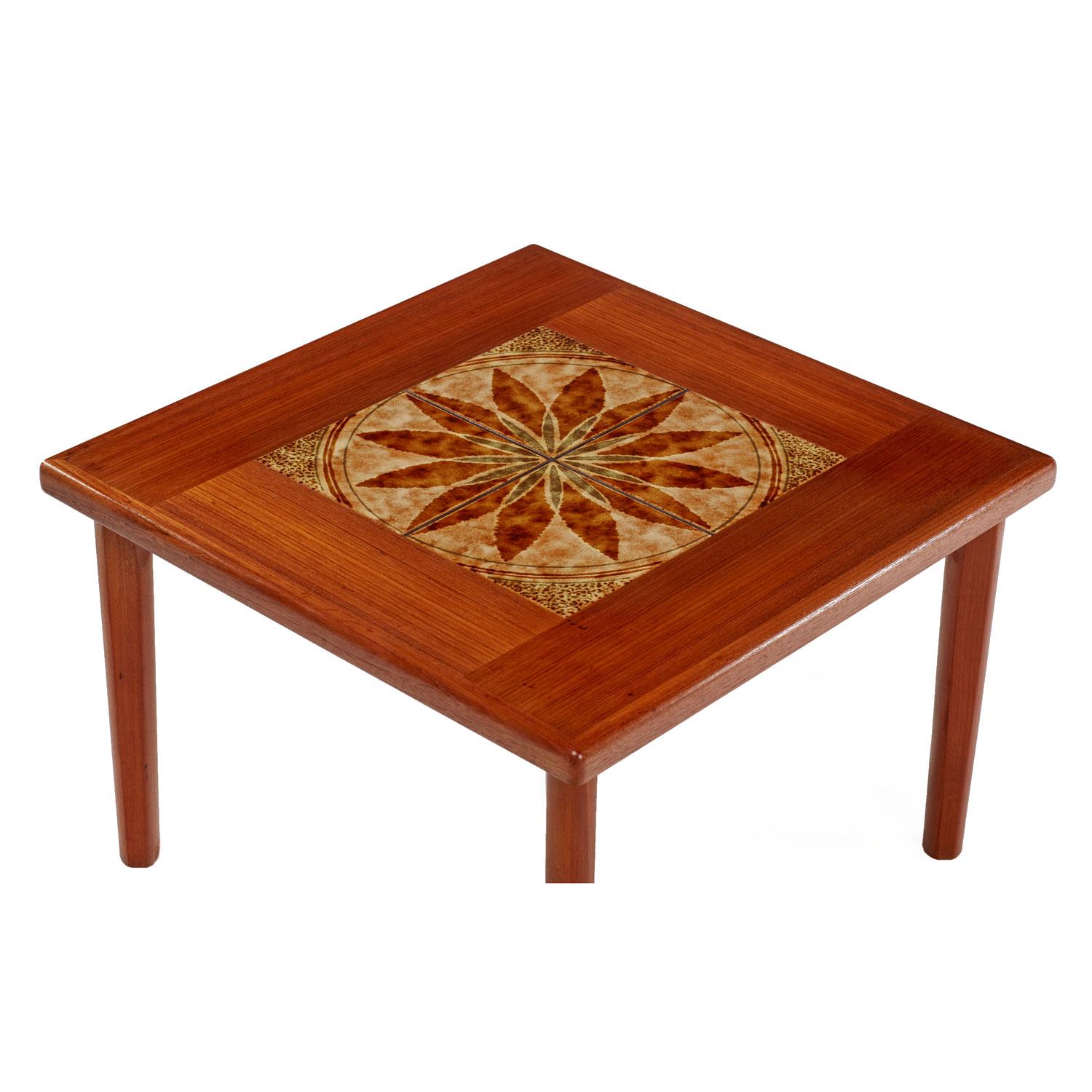 Danish teak end table made by BRDR Furbo. Rich, dark amber patina and stunning cathedral grain teak. We’ve never seen a tile top Danish teak end table with this unique design. The marijuana-like leafs are laid out in a sunburst pattern and have a