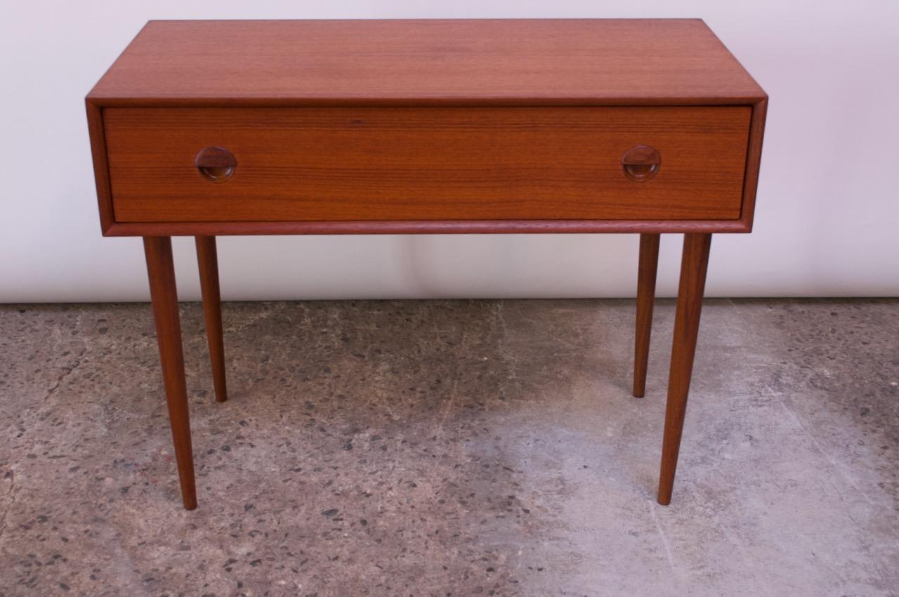 Povl Dinesen teak petite desk efficiently compact with a pull-out / drop down surface concealing additional storage (three small drawers and filing compartment with open storage in the center). Converts by pulling the drawer out and pushing in the