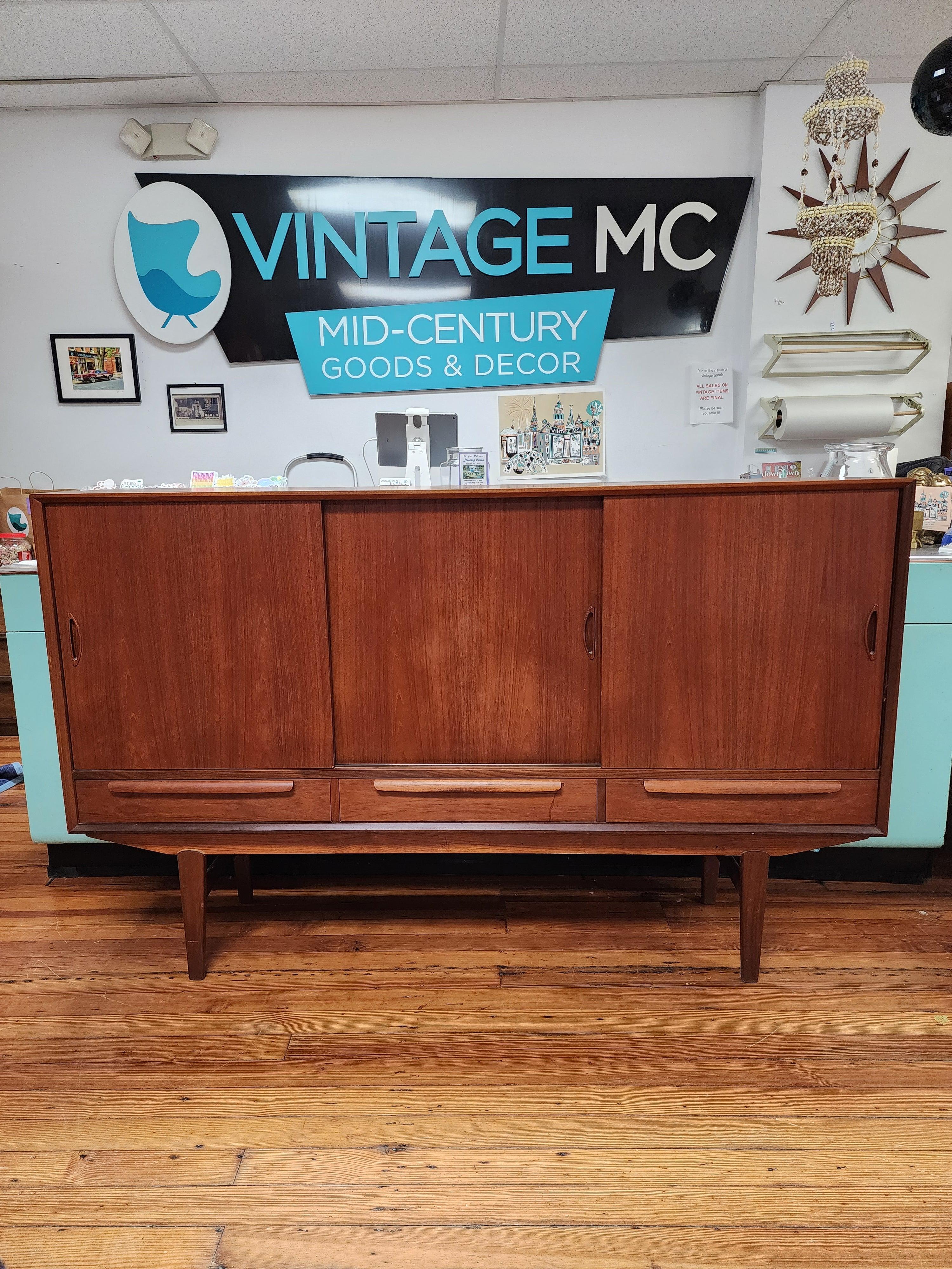 This beautiful vintage Danish teak tall sideboard has a lot of storage space. One of the coolest features of this piece is the mirrored back behind the middle section for your Barware storage. 
This item was purchased in Denmark from the original