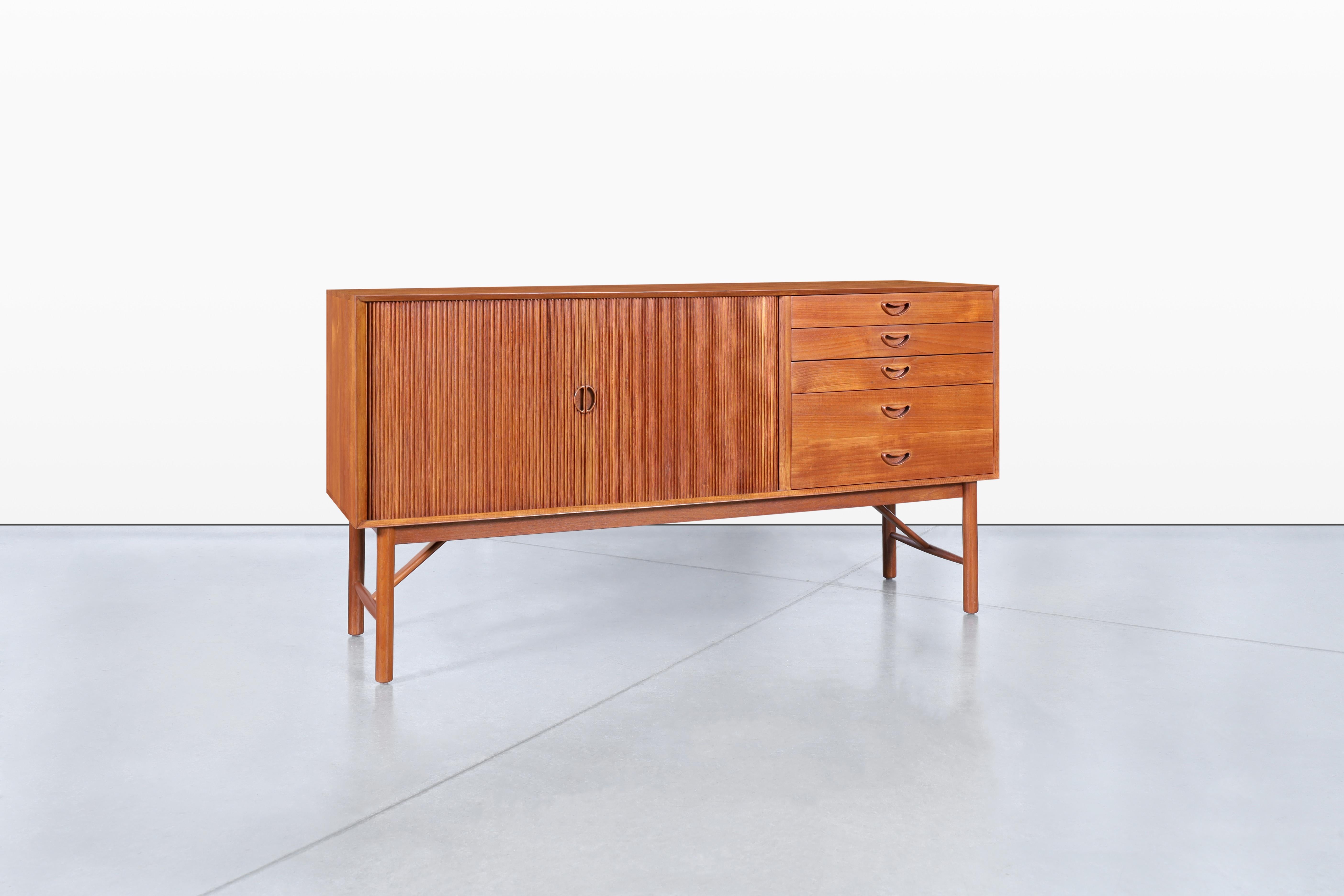 Découvrez l'élégance du design moderne danois avec cette superbe crédence à porte tambour, fabriquée de main de maître par Peter Hvidt et Orla Mølgaard-Nielsen pour Søborg dans les années 1960. Cette pièce étonnante présente quatre tiroirs à queue