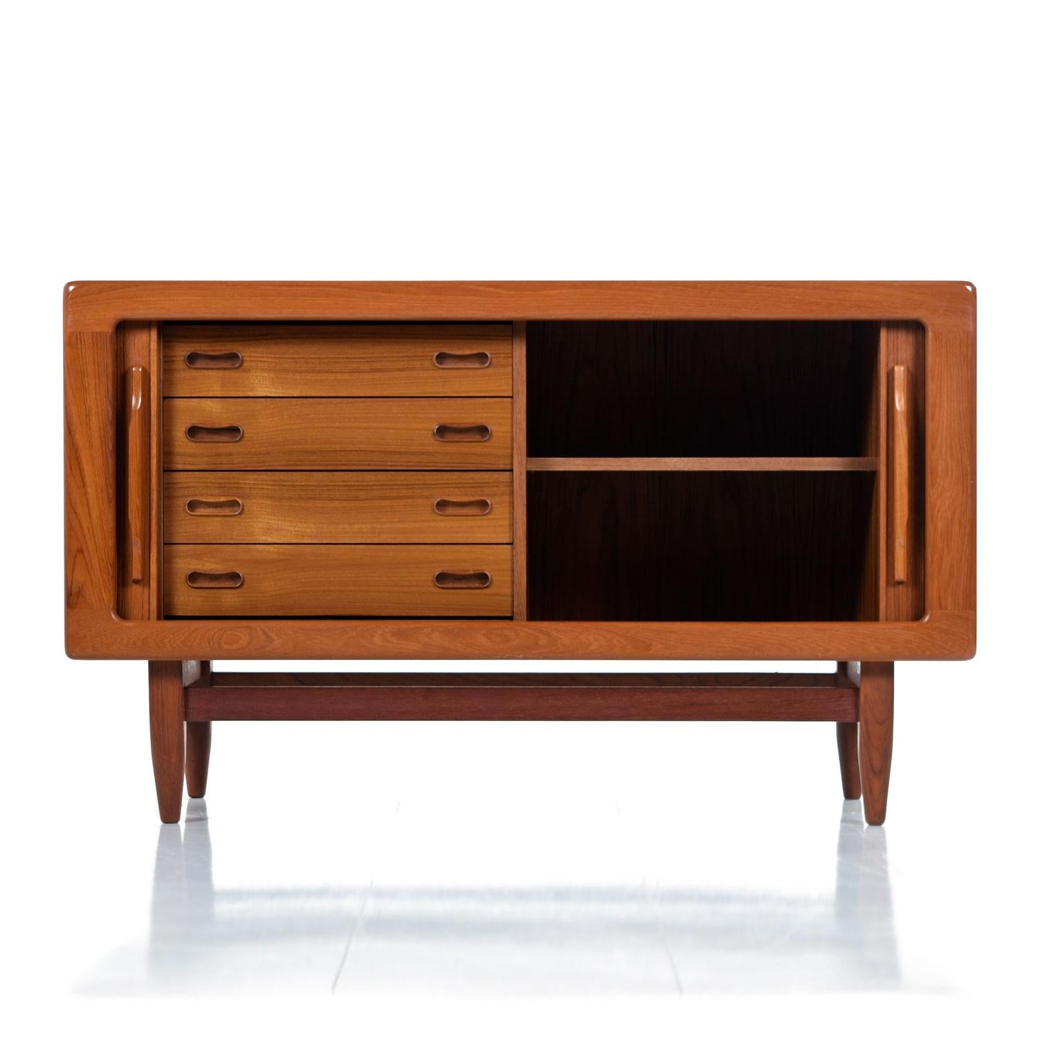 Vintage midcentury Scandinavian Modern Danish teak tambour door credenza. Ideal as a media cabinet / TV stand and deep enough to accommodate 12? LP’s. Expertly crafted with sleek lip-like, solid teak carved handles gracing the tambour doors. Open