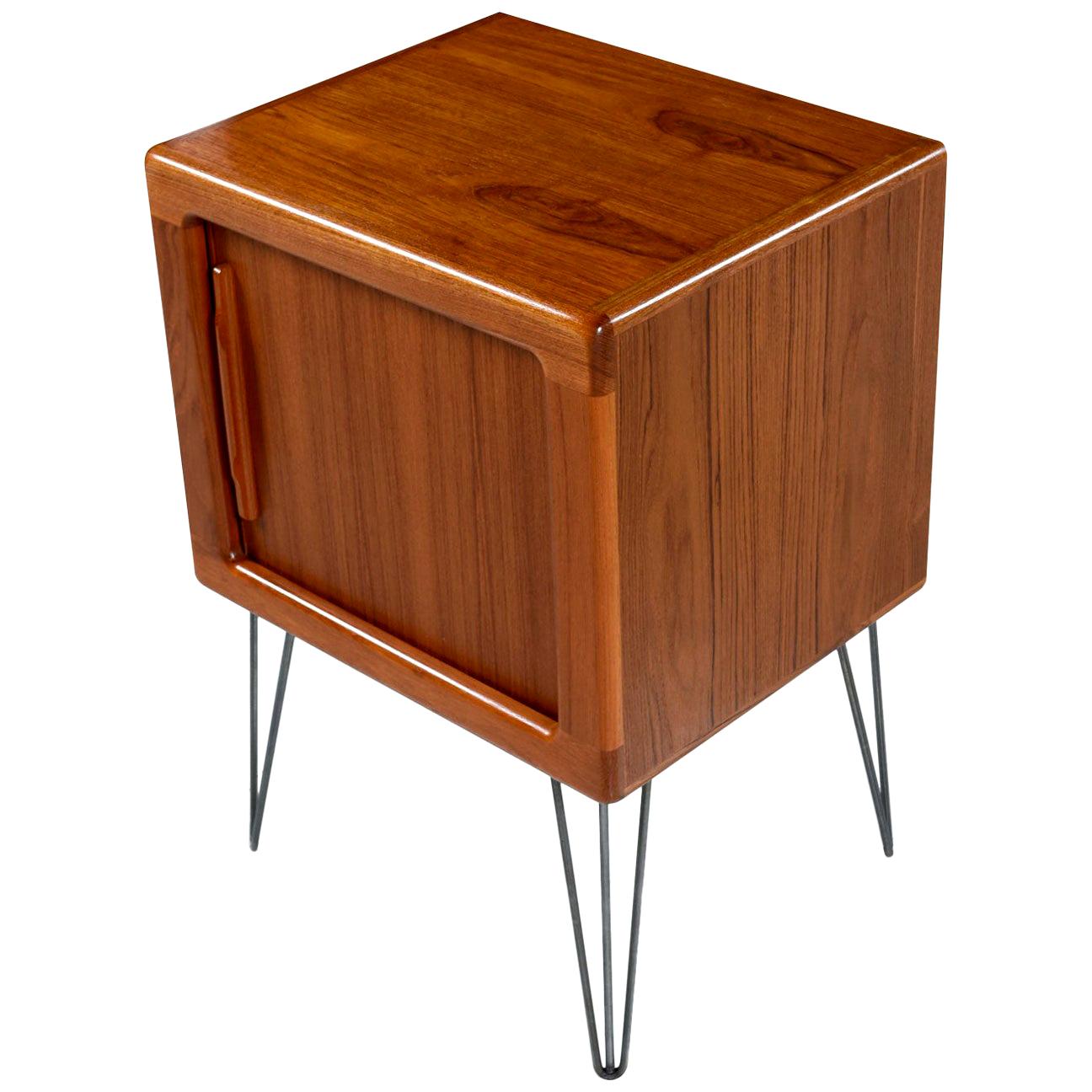 Vintage midcentury Scandinavian Modern Danish teak tambour door cabinet / nightstand. Ideal as a media cabinet / TV Stand and deep enough to accommodate 12 inch LP’s. Expertly crafted with sleek lip-like, solid teak carved handles gracing the