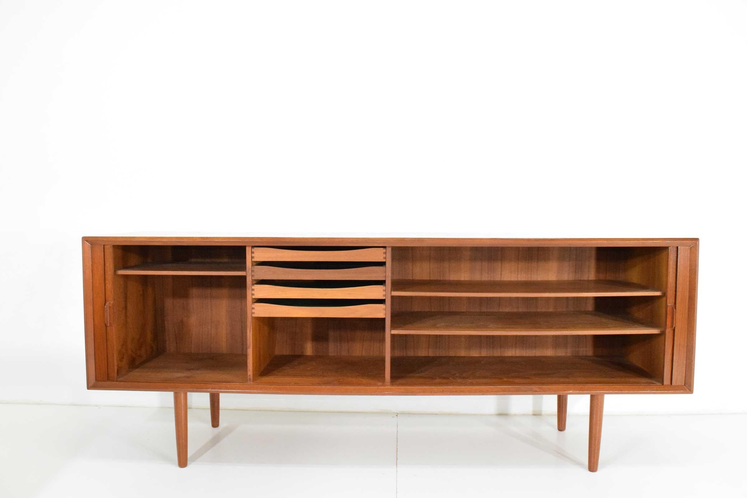 Mid-Century Modern. Beautiful teak wood with lots of shelving and storage. Tambour doors recess so not to worry about doors getting in the way. This sideboard/credenza has been restored beautifully so it is like new but has the aged quality teak